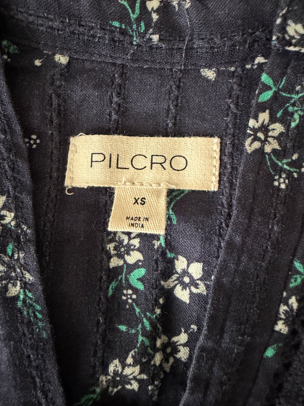 Pilcro label on a black fabric with floral patterns