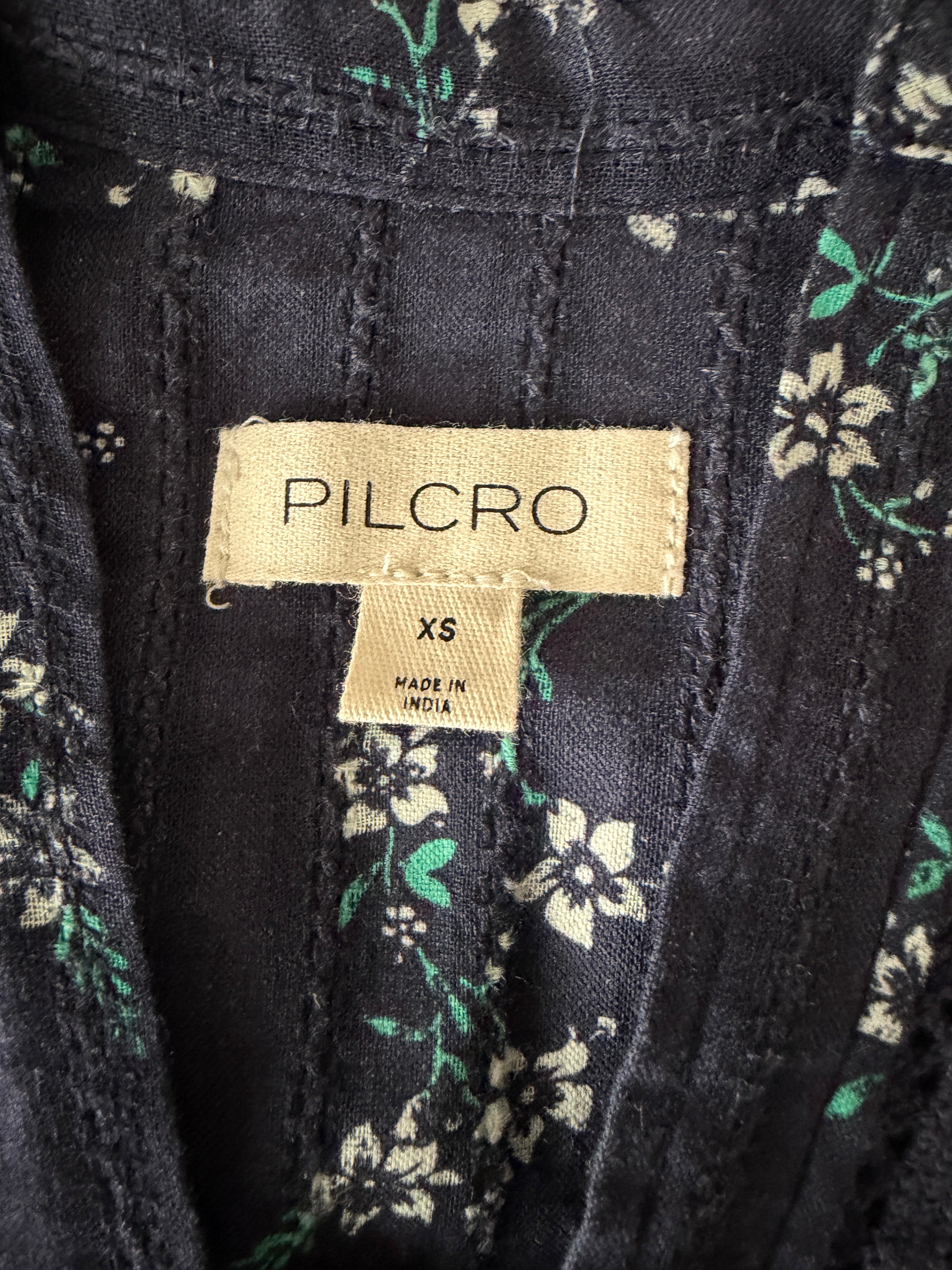 Pilcro label on a black fabric with floral patterns