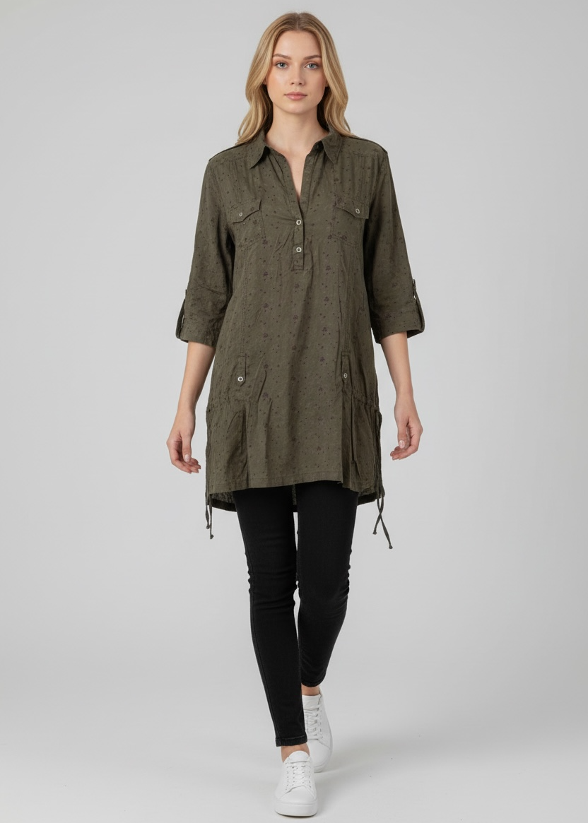 Woman wearing a green dress with long sleeves and black leggings on a white background