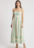 Woman wearing a strapless dress with green and white pattern on a white background