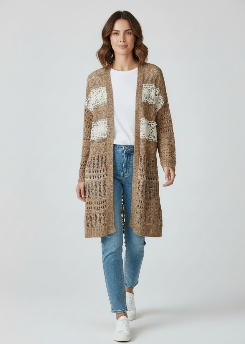 Woman wearing a long brown cardigan with white patterns, white shirt, blue jeans, and white sneakers on a white background.