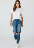 Woman wearing a white t-shirt and blue jeans on a plain background