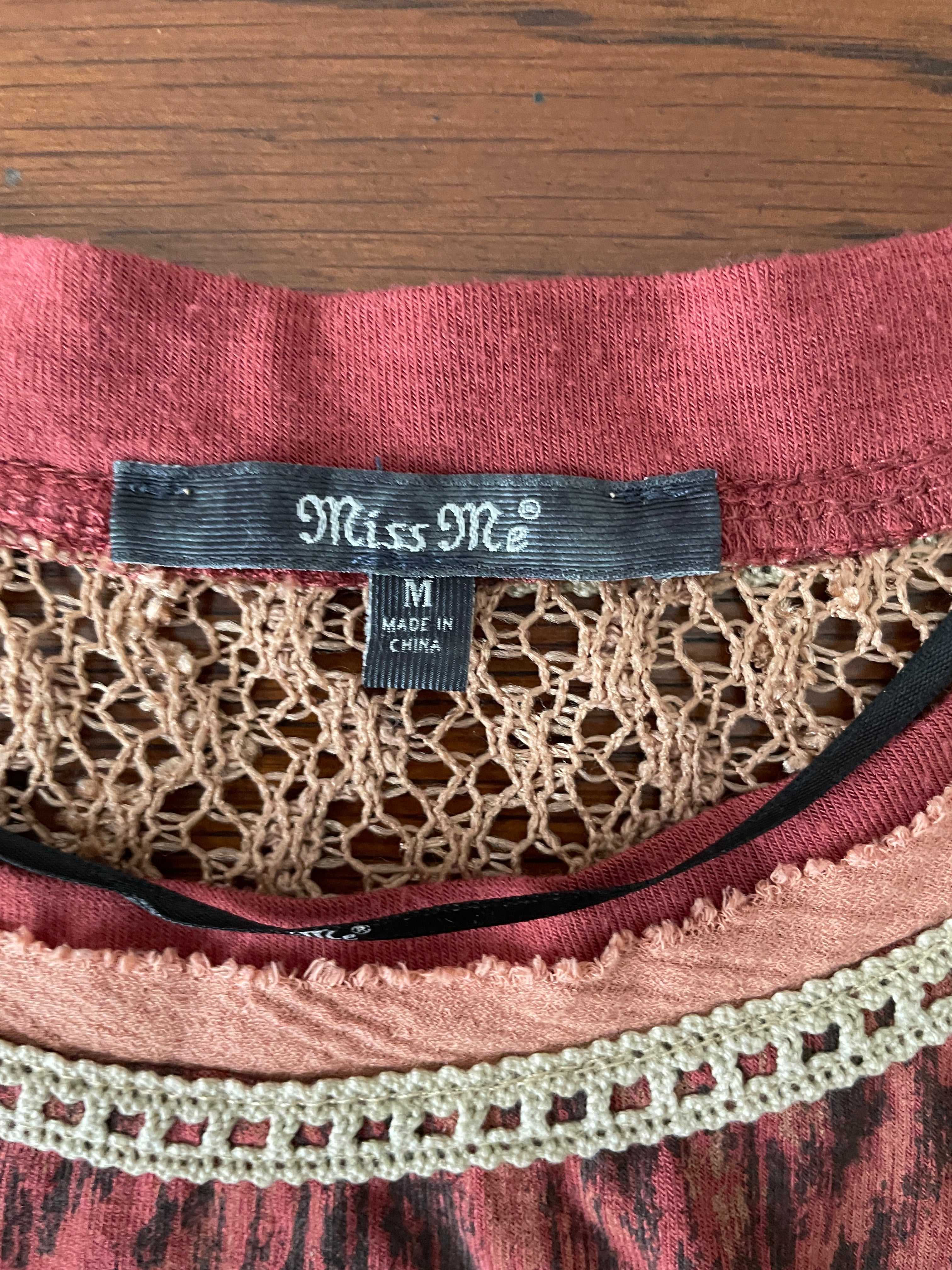 Close-up of a label on a piece of clothing with intricate lace detailing.