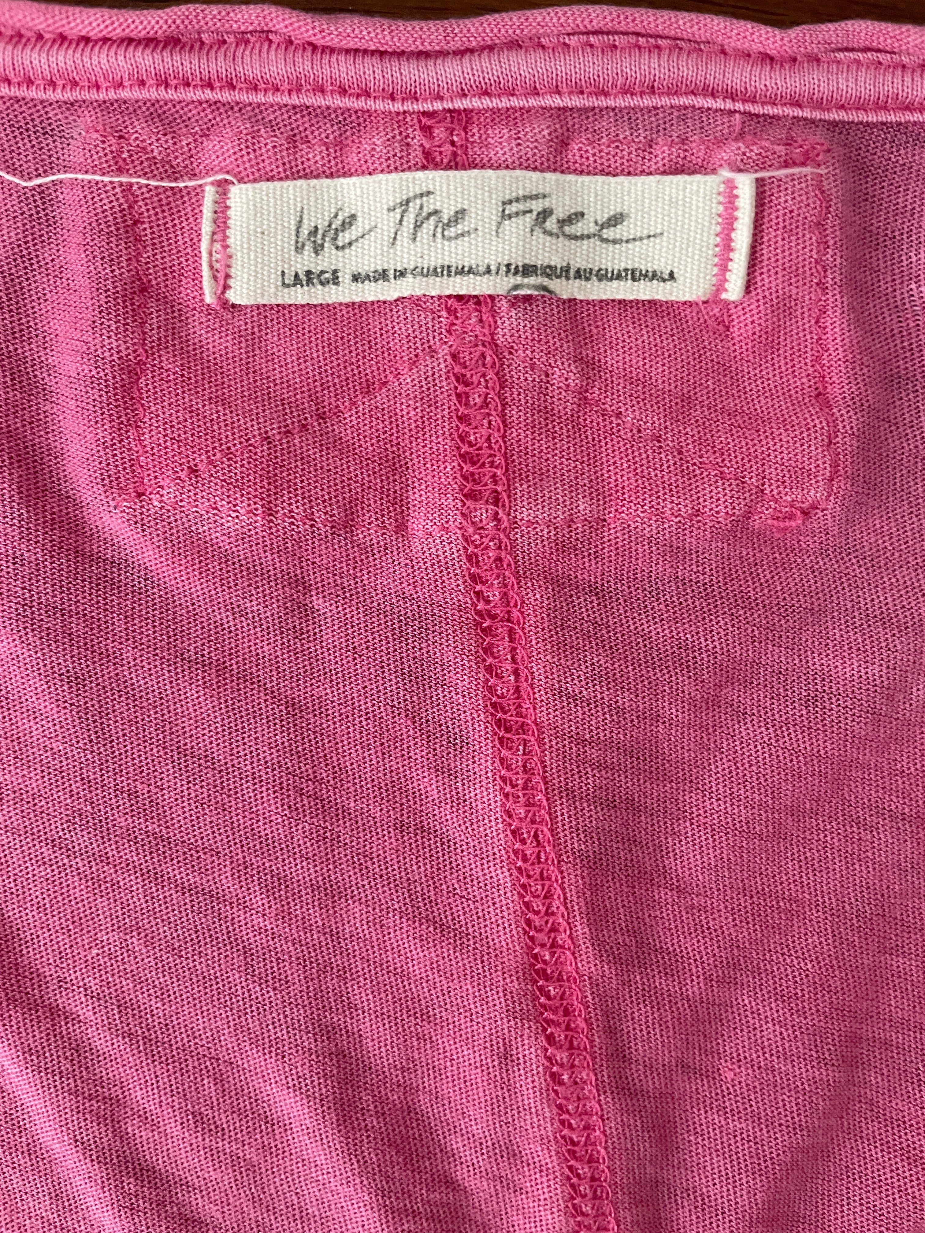 Close-up of pink fabric with a label on a brown background