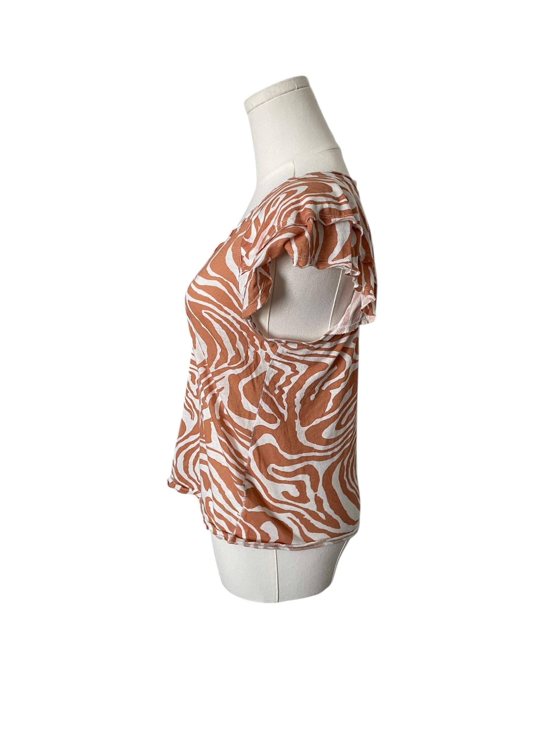 Mannequin wearing a patterned orange and white top on a white background