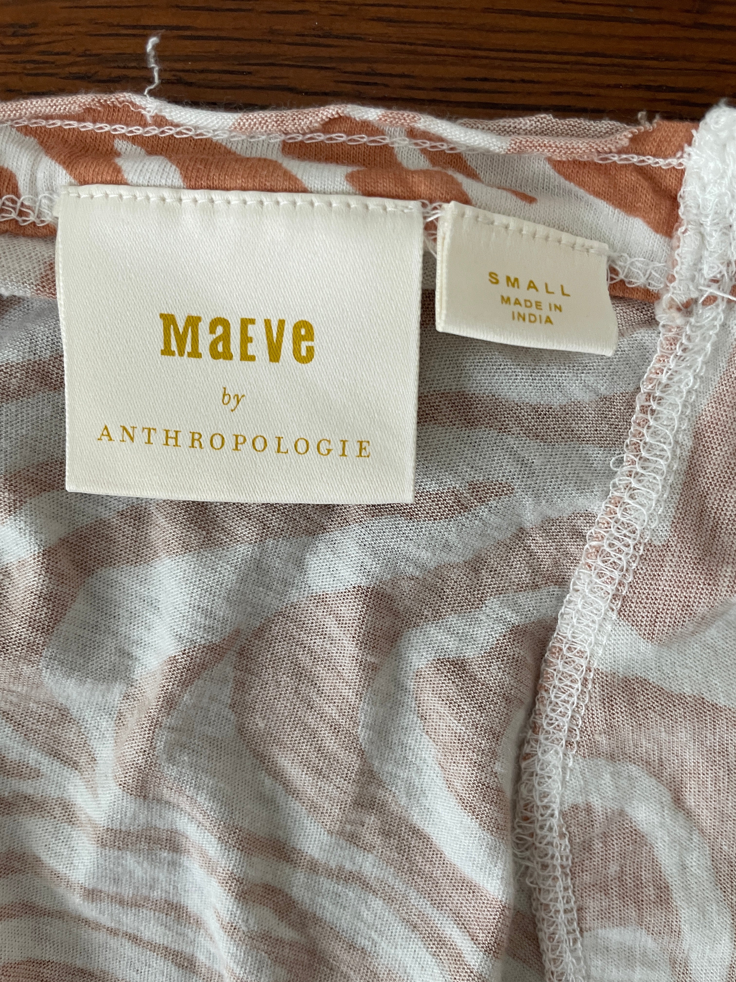 Fabric with 'Maeve by Anthropologie' label on a wooden surface