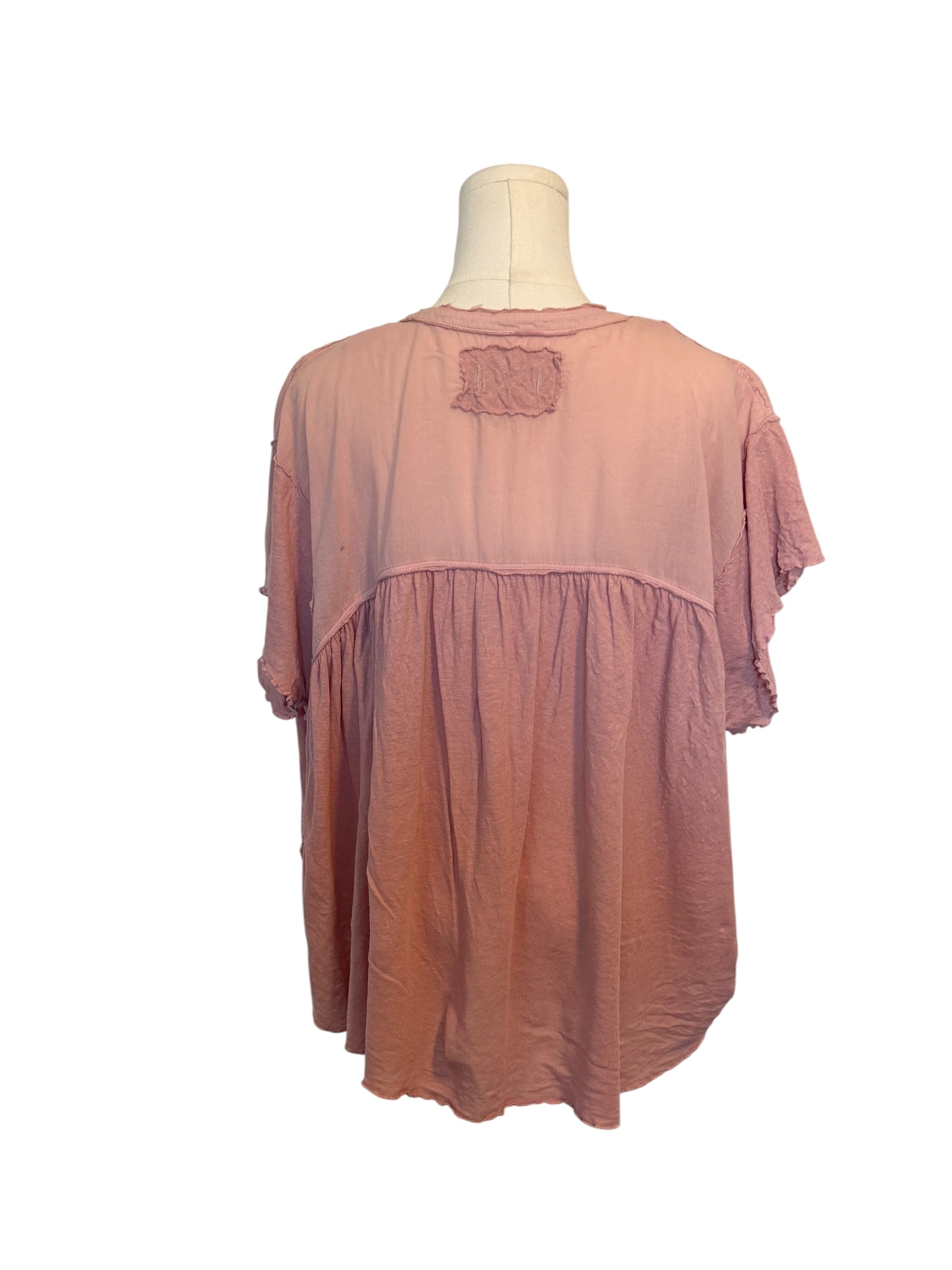 Pink blouse on a mannequin against a white background