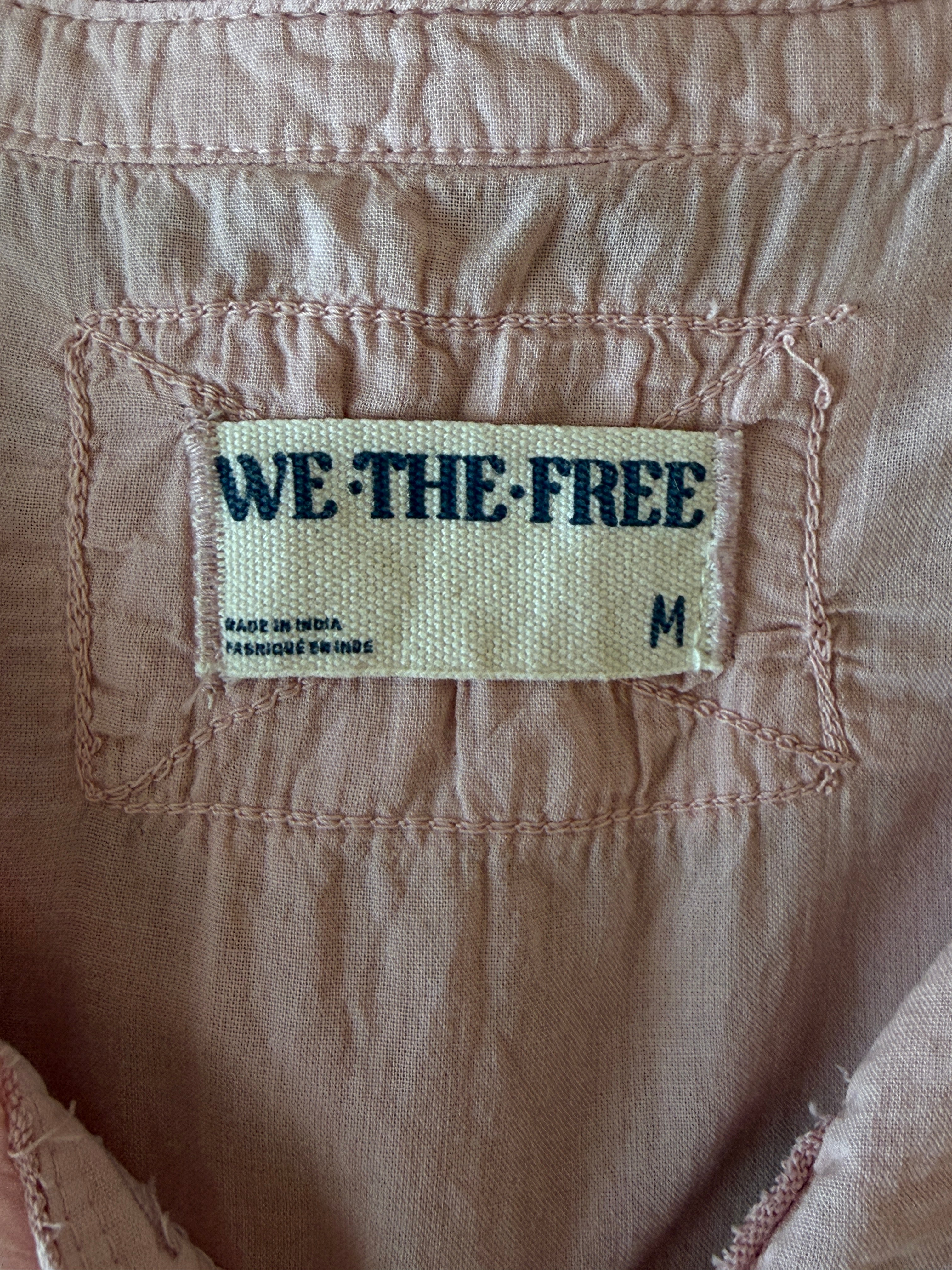 Fabric tag with 'WE THE FREE' text on a brown background