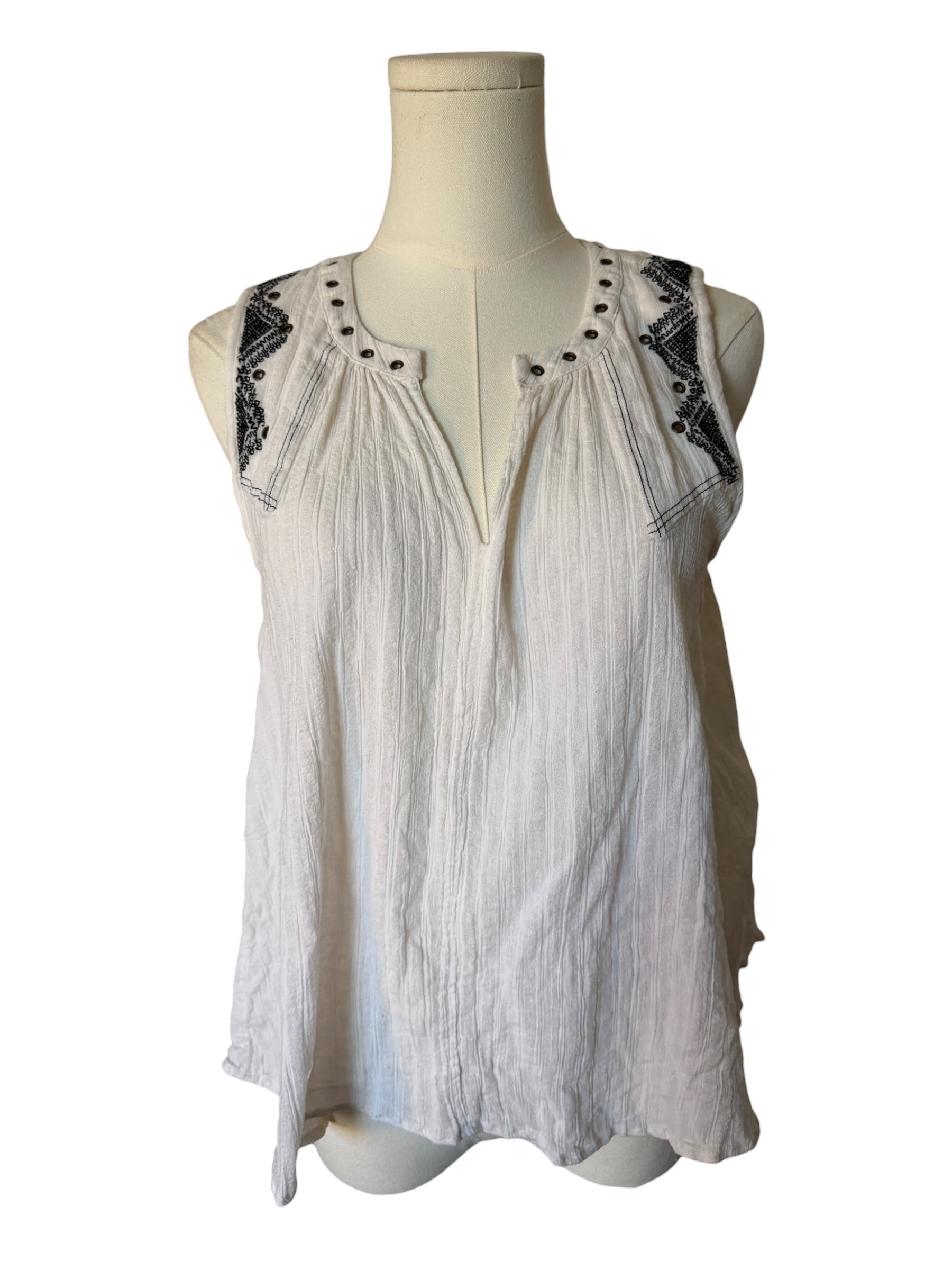 White sleeveless top with black lace details on a mannequin against a white background