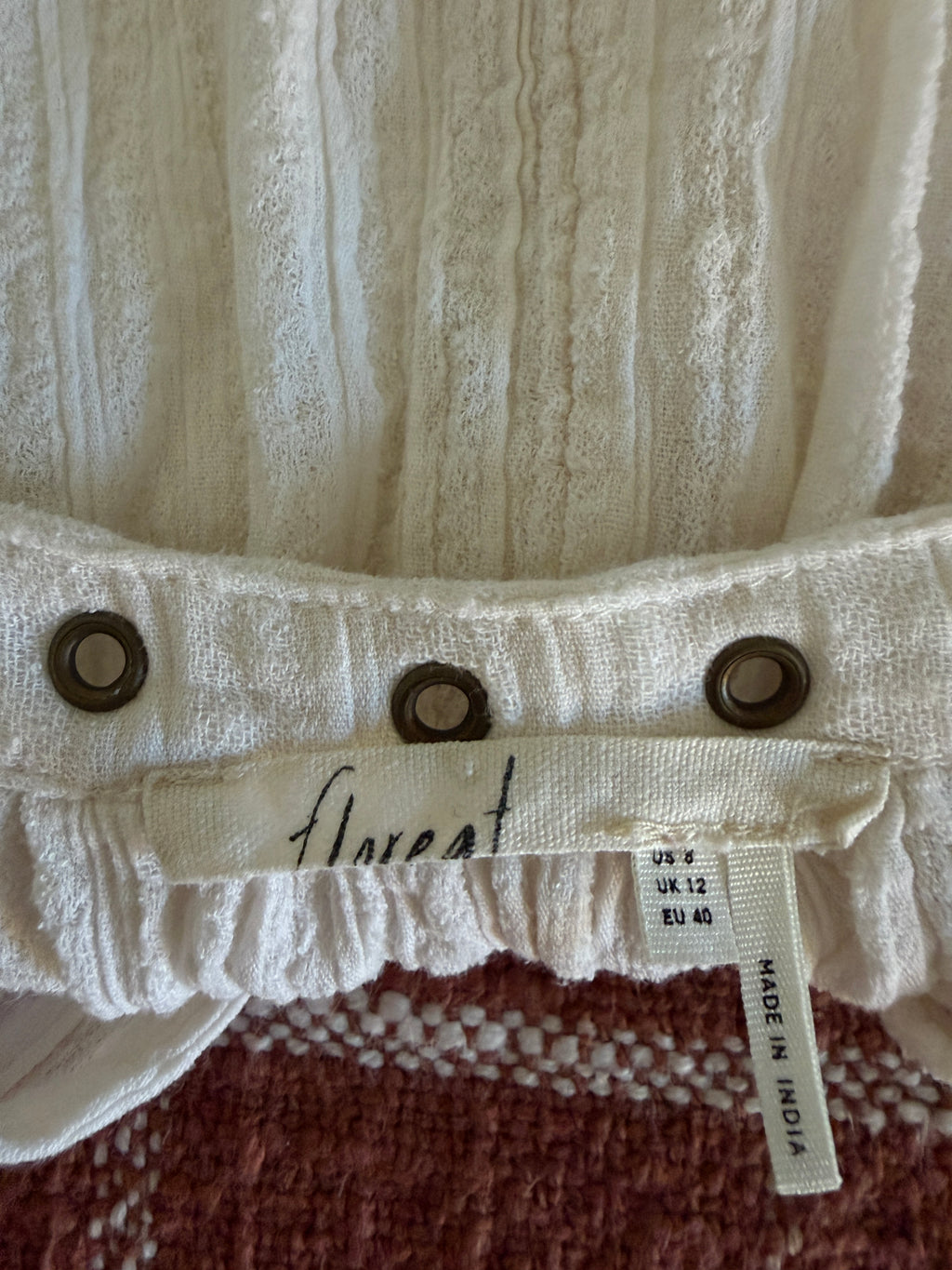 Close-up of a textured fabric with buttons and a label on a brown background