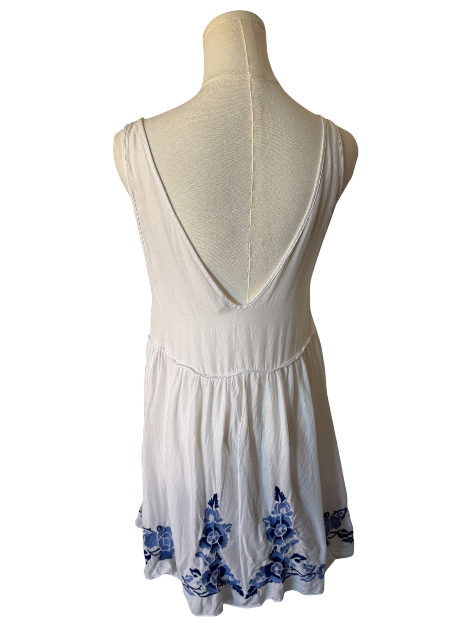 White dress with blue floral patterns on a mannequin against a white background