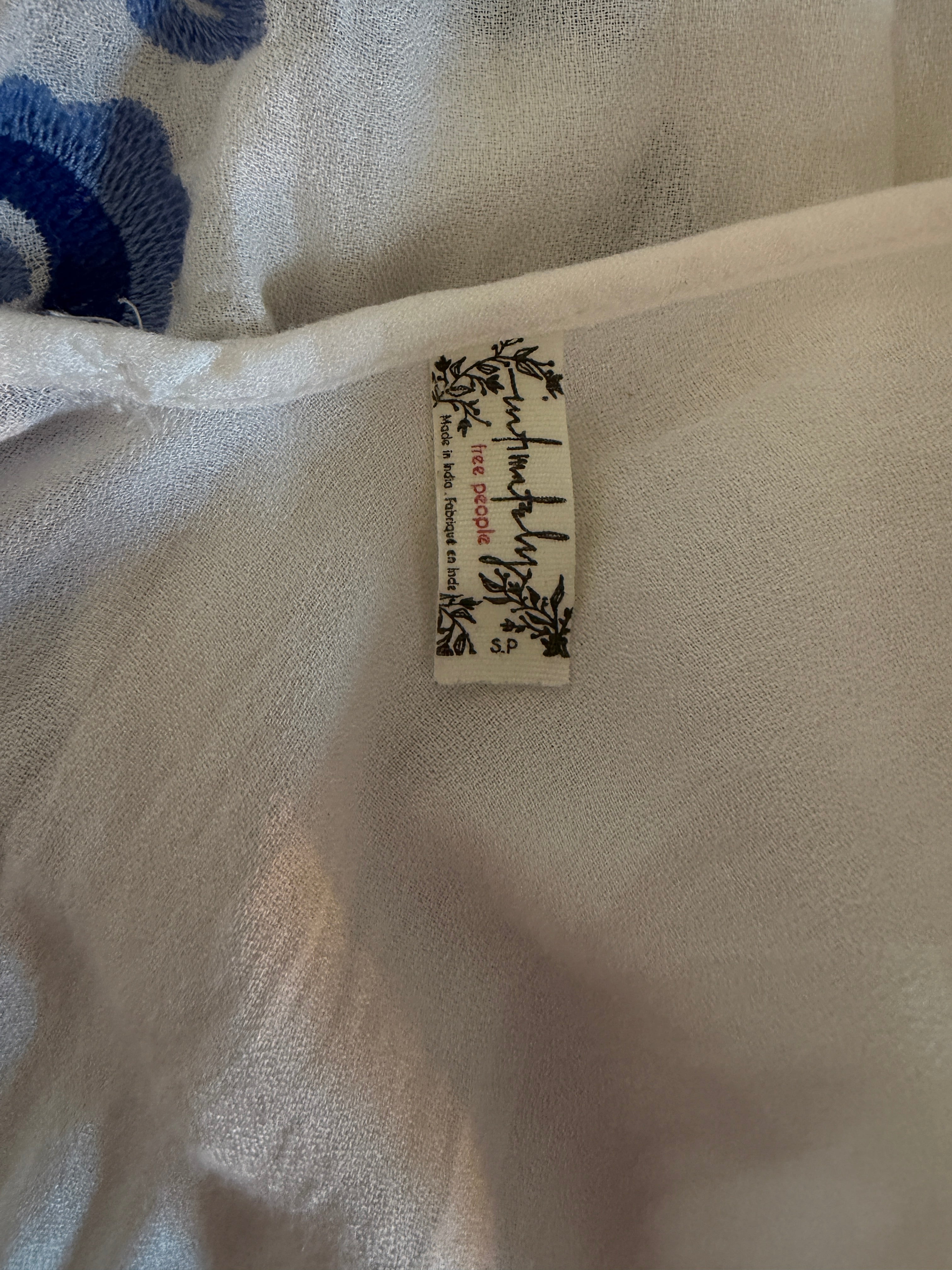 Fabric tag on a piece of fabric with floral embroidery