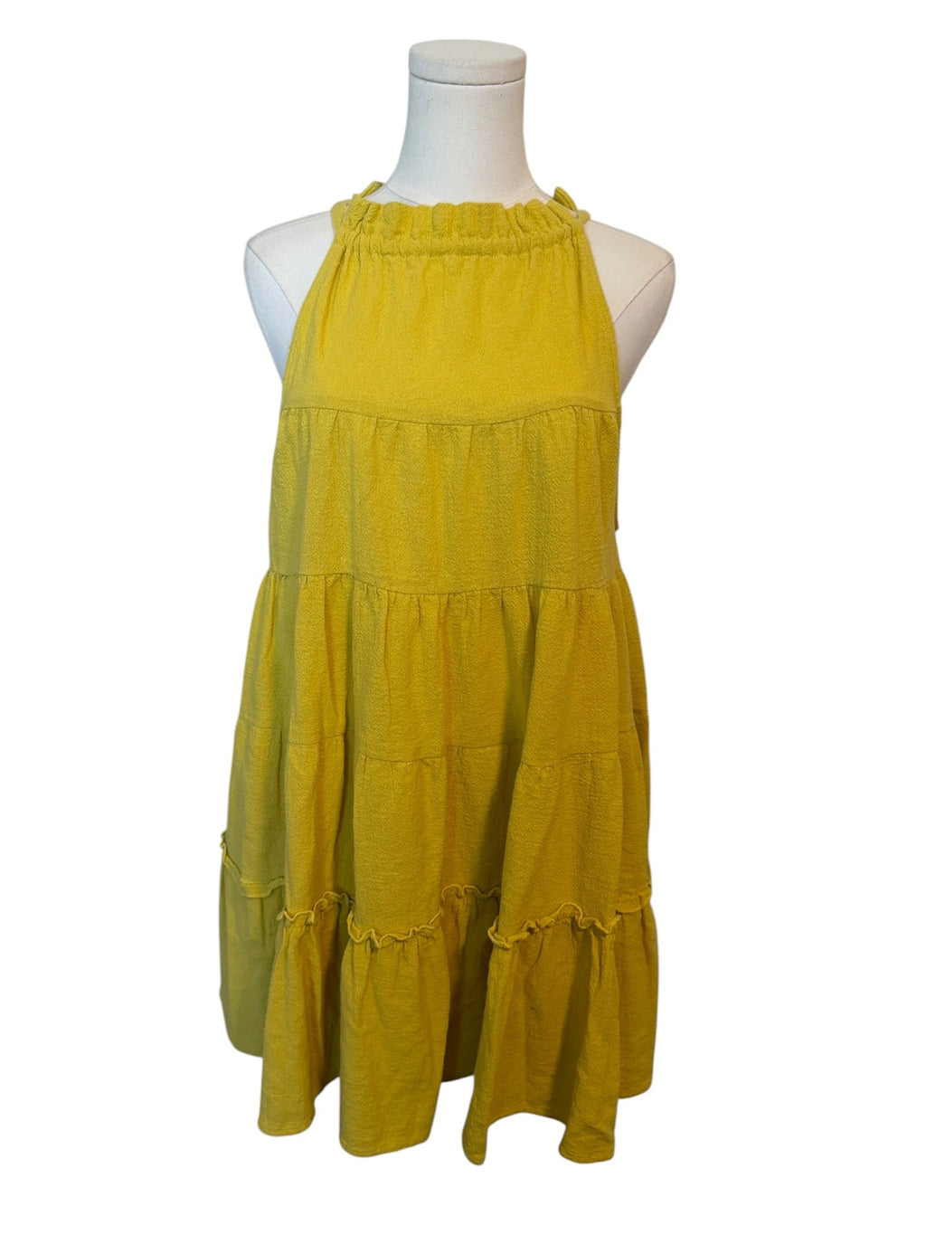 Yellow dress on a mannequin against a white background
