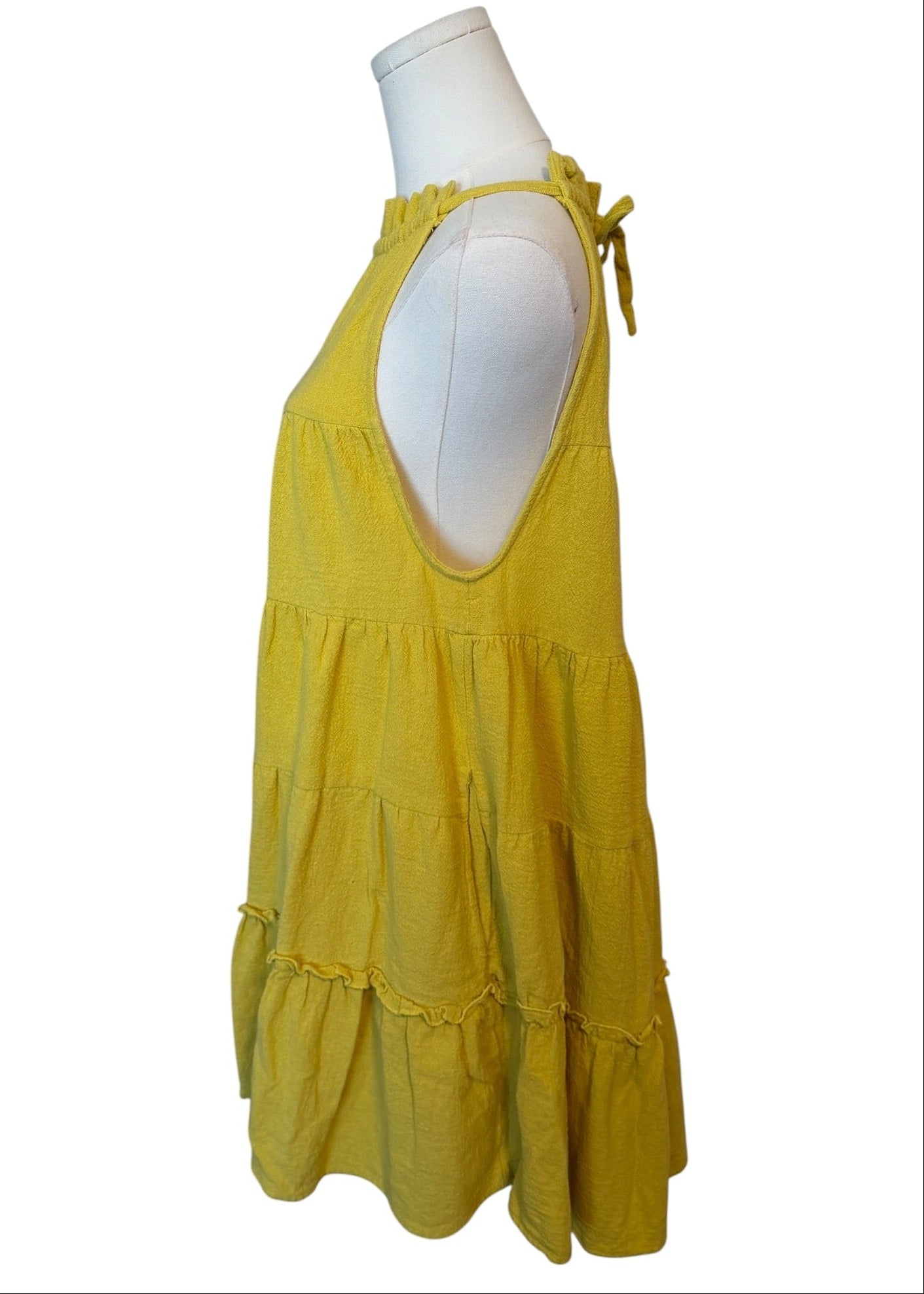 Yellow dress on a mannequin against a white background