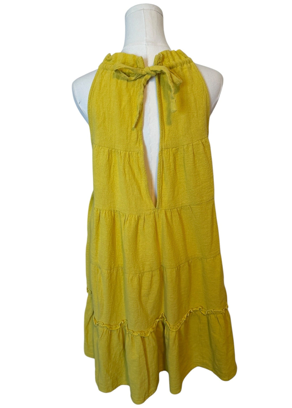 Yellow dress on a mannequin against a white background