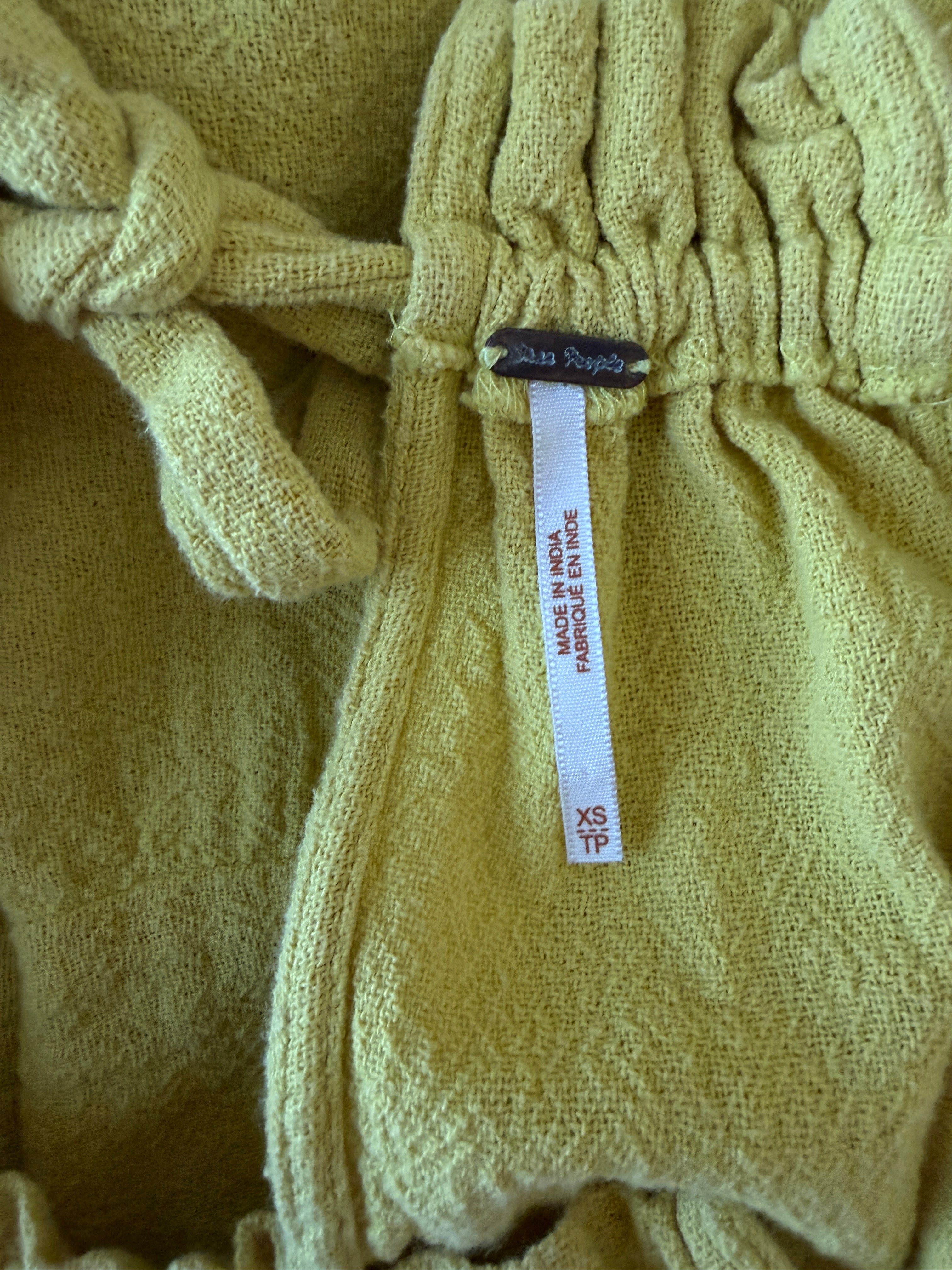 Close-up of a light green fabric with a tag on a textured background