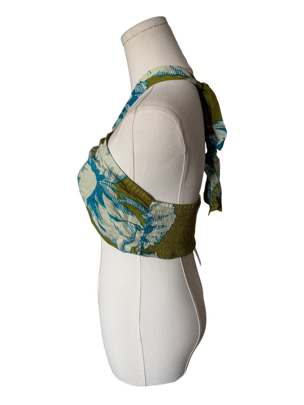 Green and blue patterned top on a mannequin against a white background