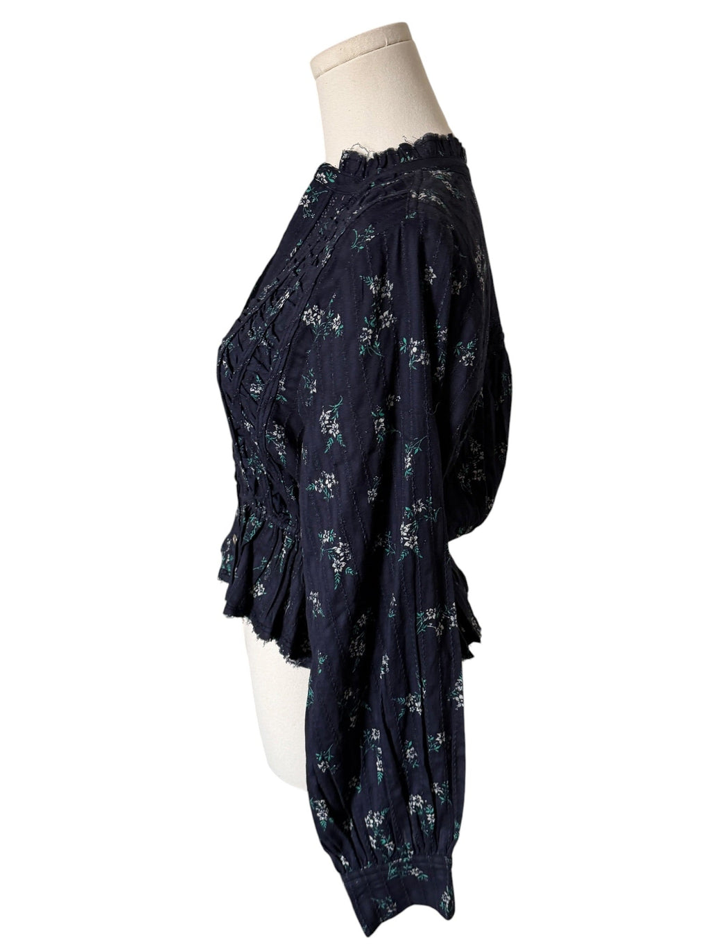 Navy blue floral blouse on a mannequin against a white background