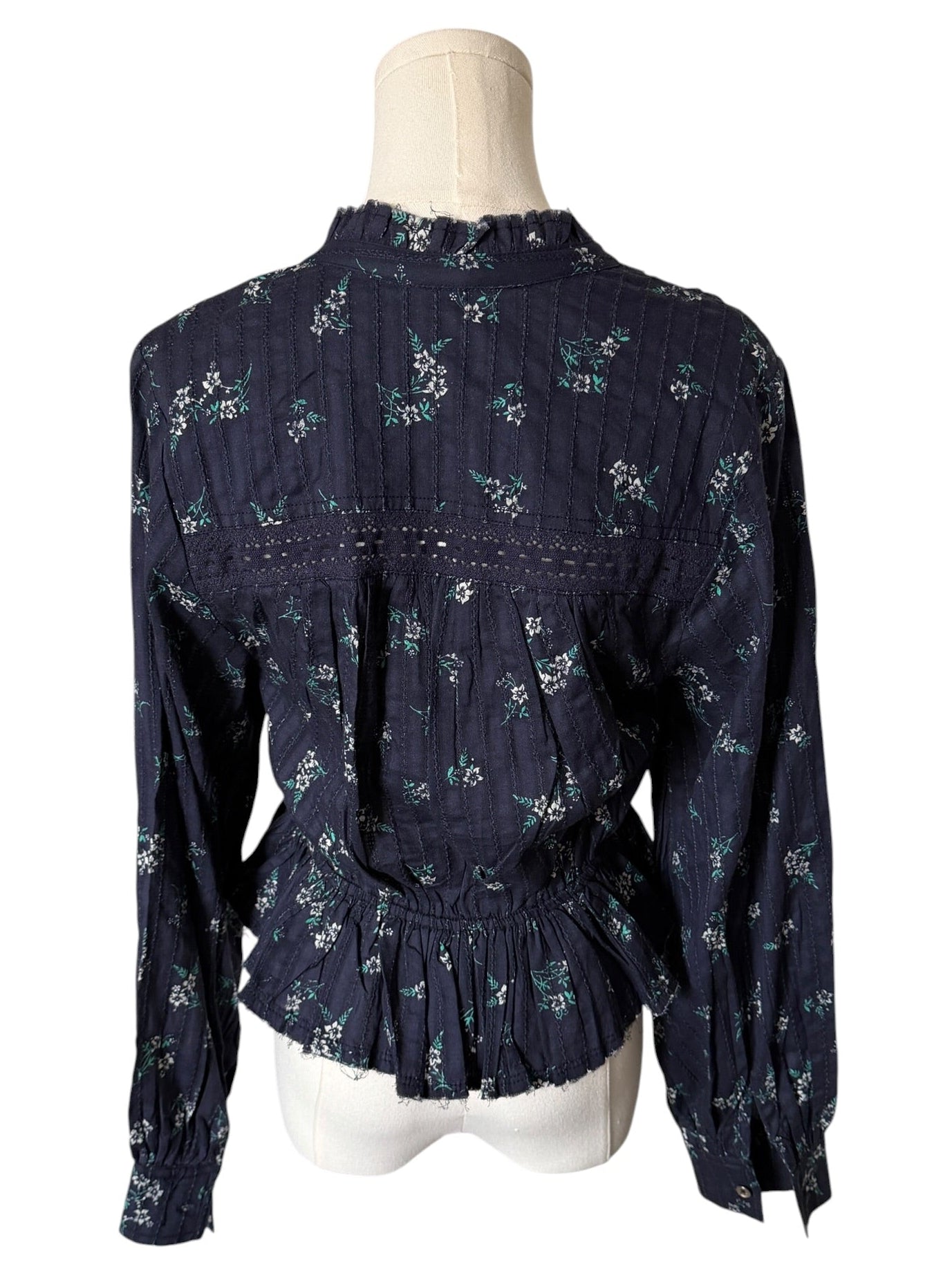 Navy blue floral blouse on a mannequin against a white background