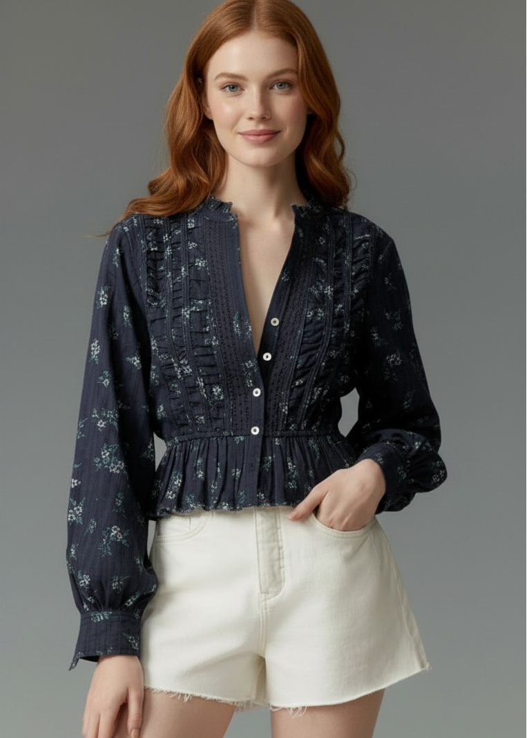 Woman wearing a dark blue patterned blouse and white shorts on a gray background