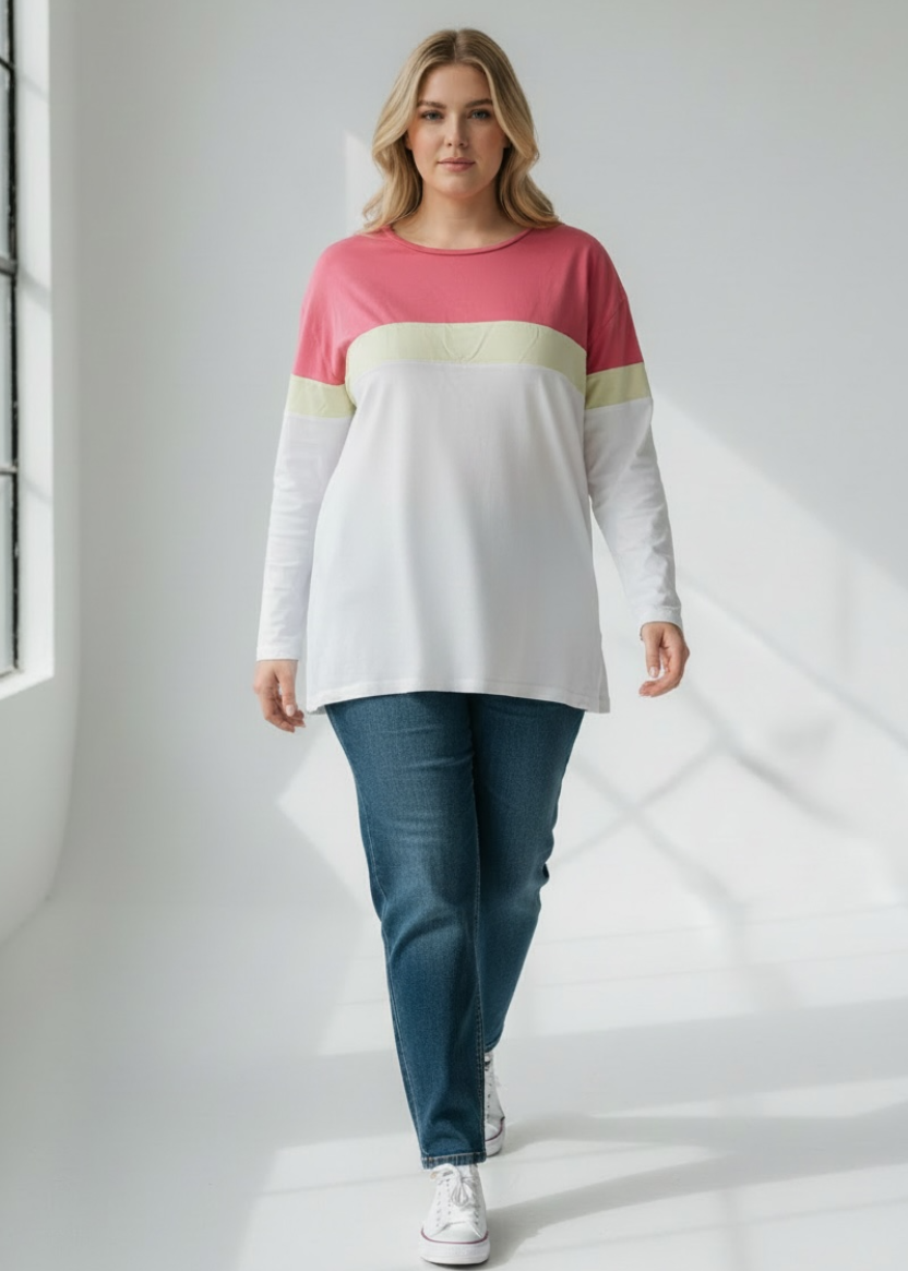 Woman wearing a colorful sweater and jeans in a bright room