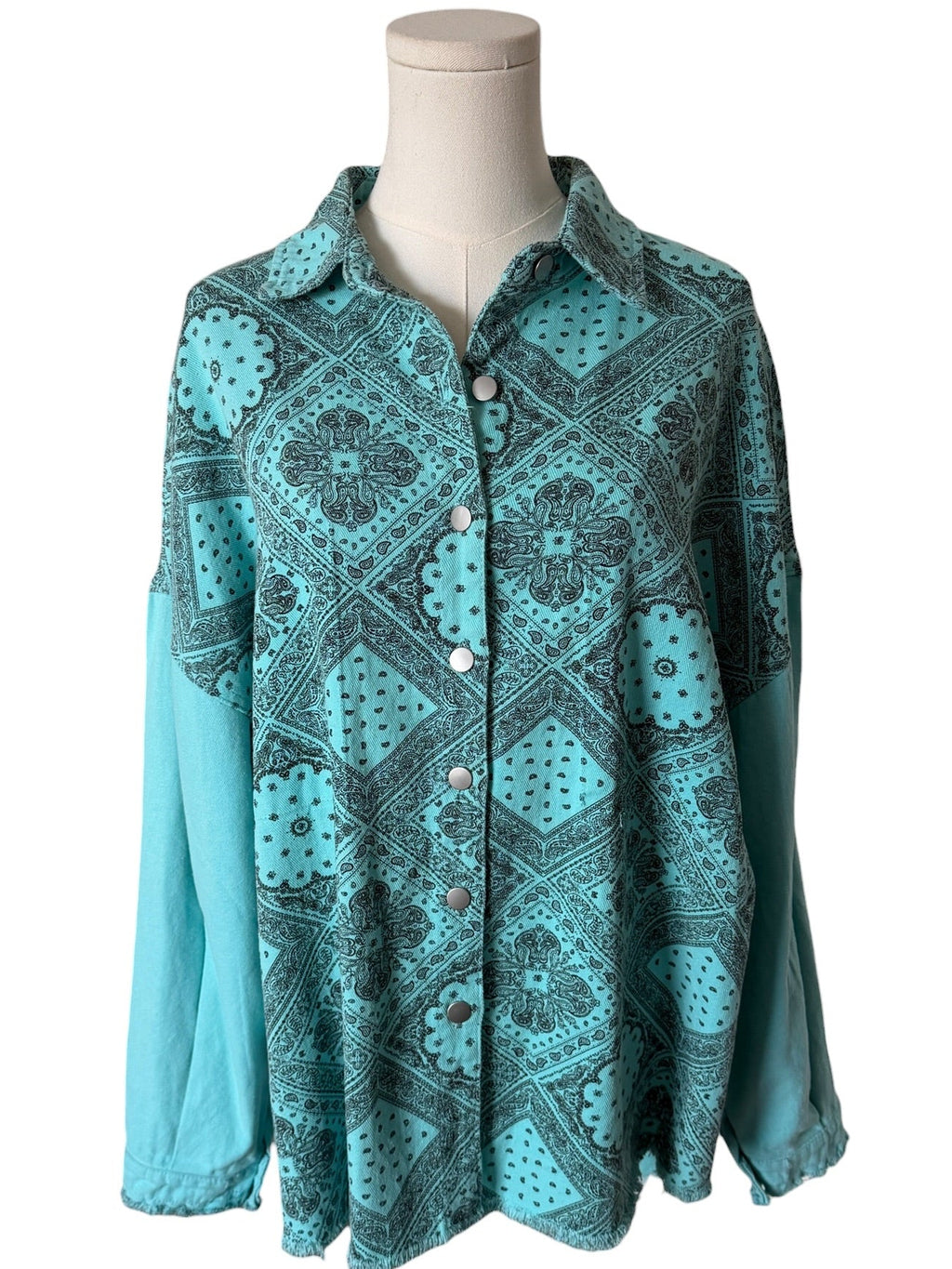Teal patterned shirt on a mannequin against a white background