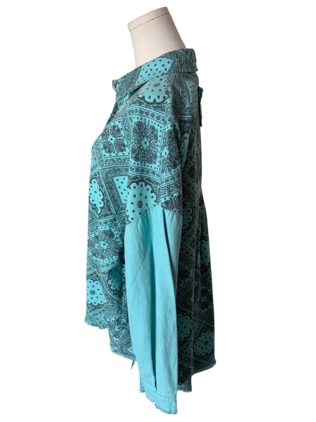 Teal patterned skirt on a mannequin against a white background