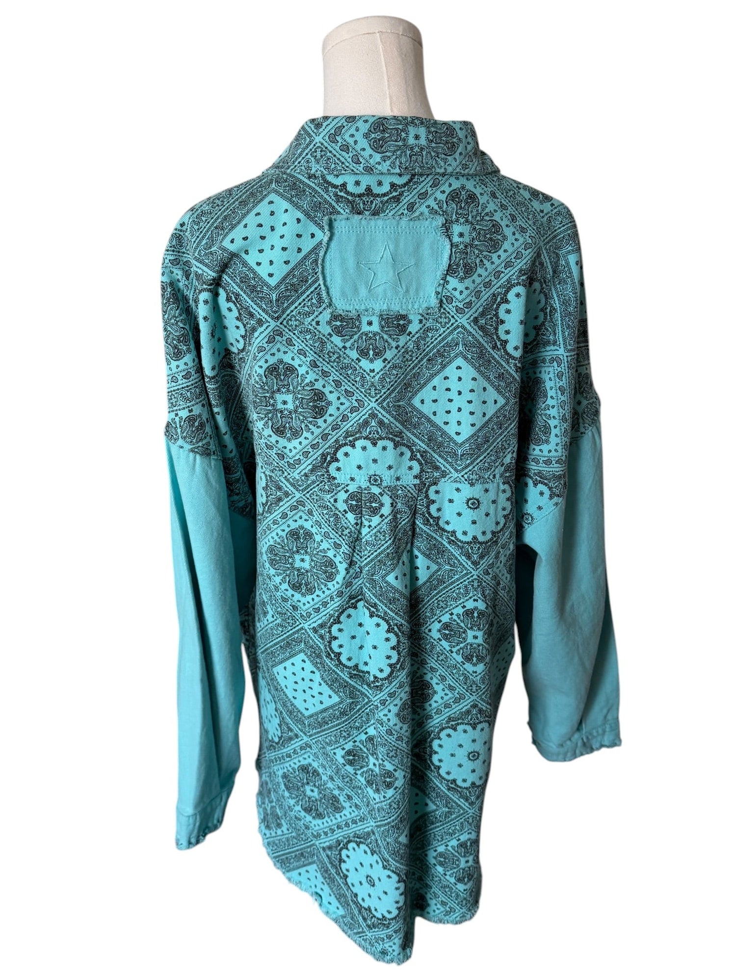 Teal patterned shirt on a mannequin against a white background