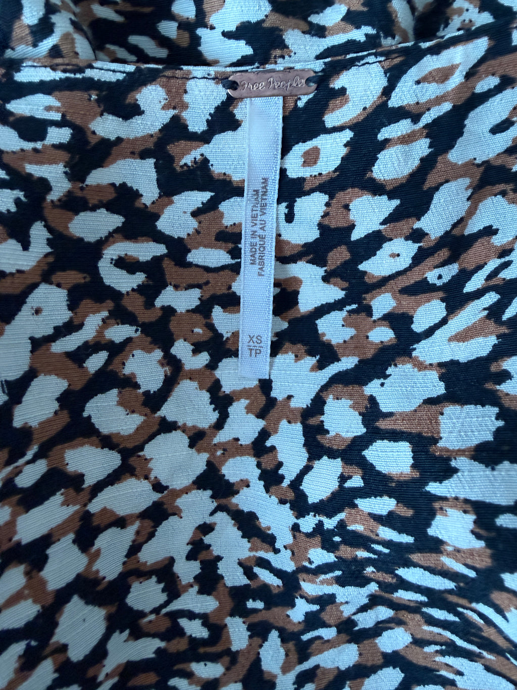 Textile with a patterned design and a visible label.