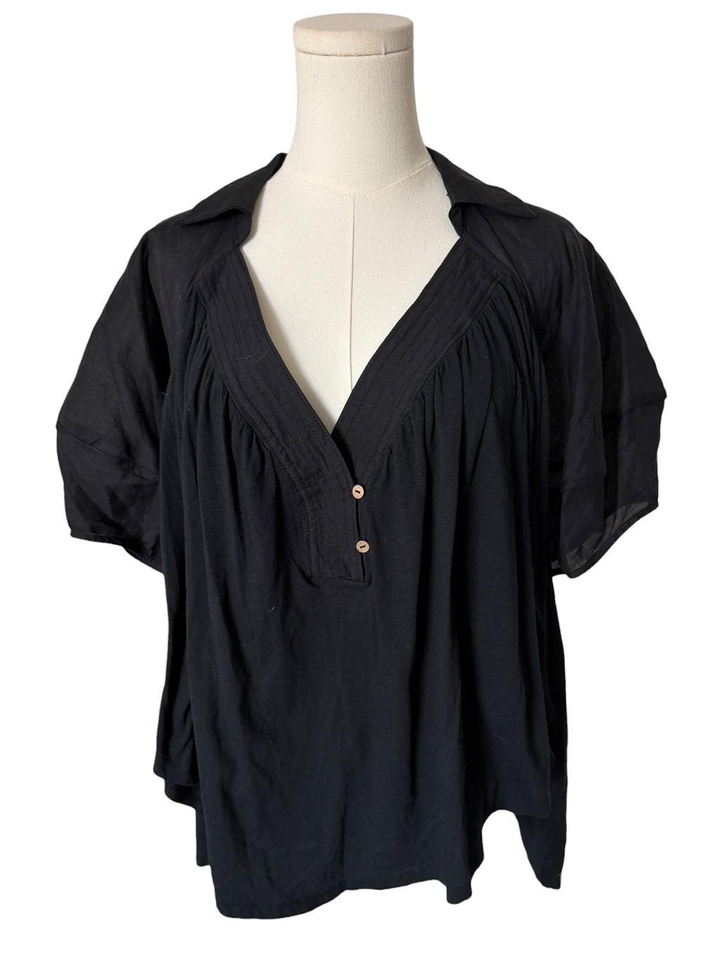 Black blouse on a mannequin against a white background