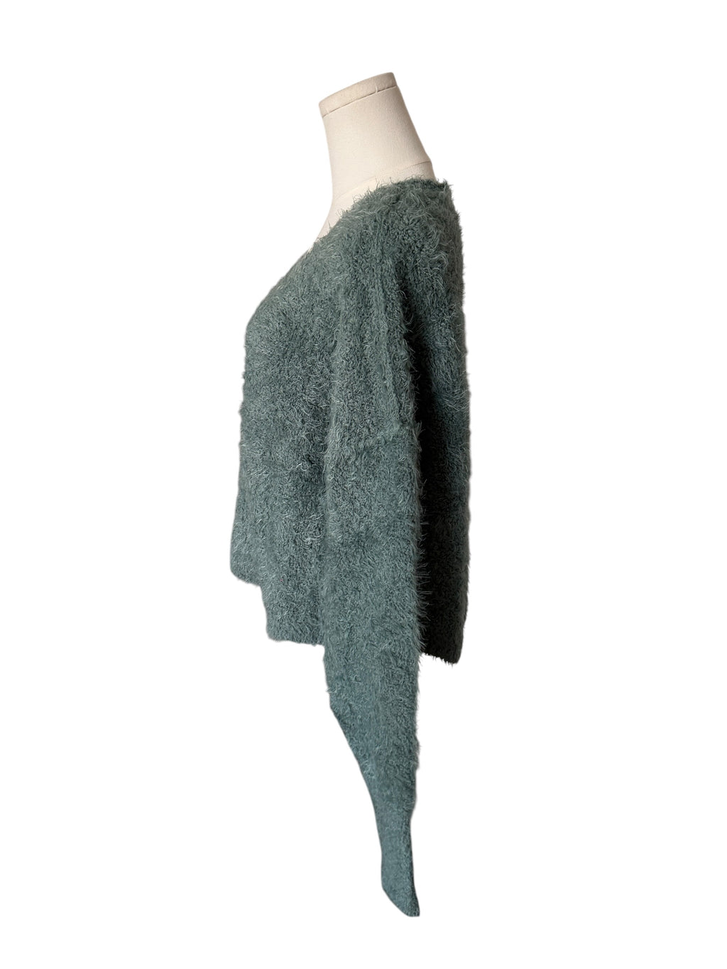 Green textured sweater on a mannequin against a white background