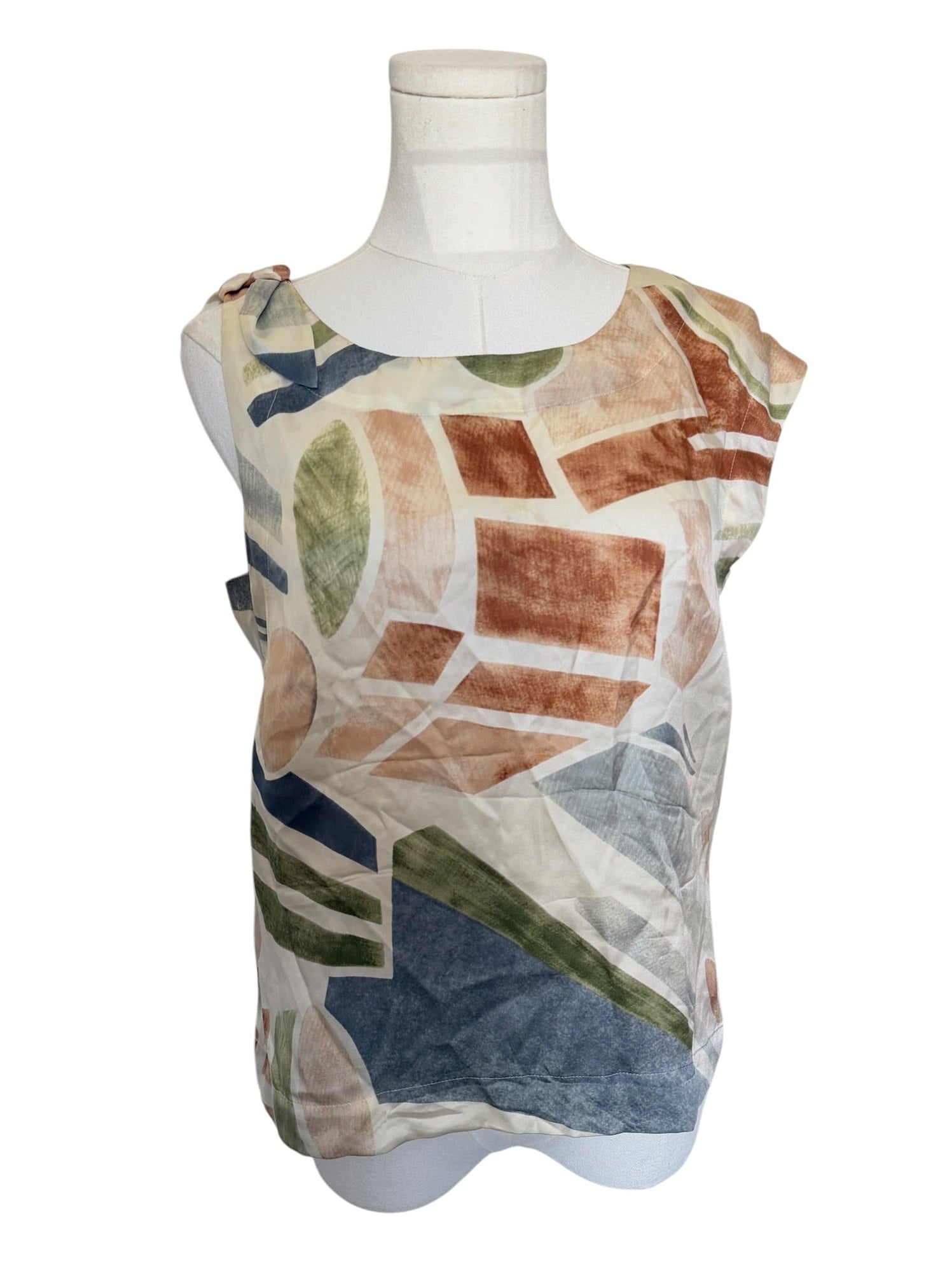 Multicolored patterned sleeveless top on a mannequin against a white background