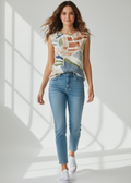 Woman wearing a sleeveless patterned top and blue jeans standing in a well-lit room.