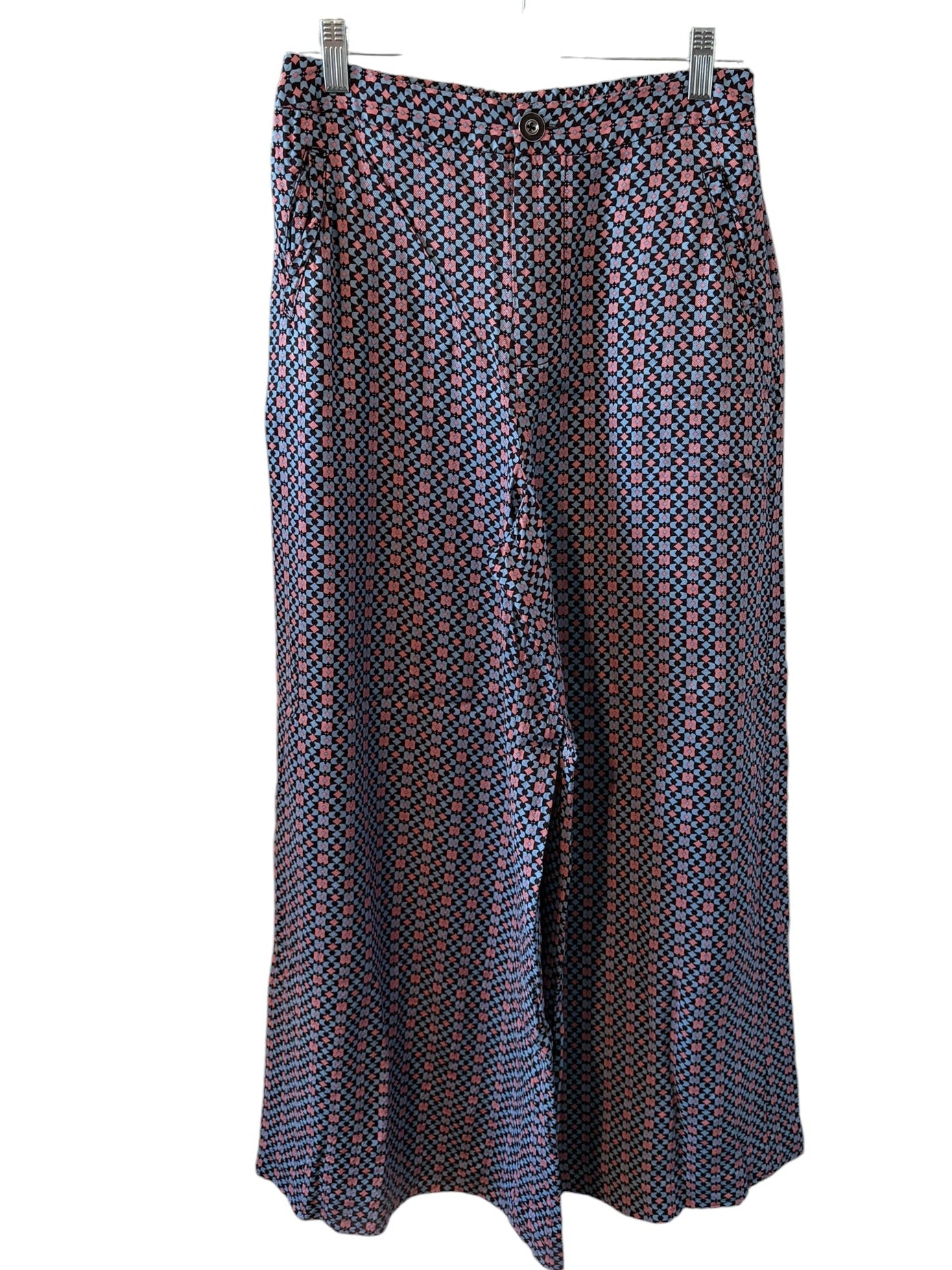 Pants with geometric pattern on a hanger against a white background