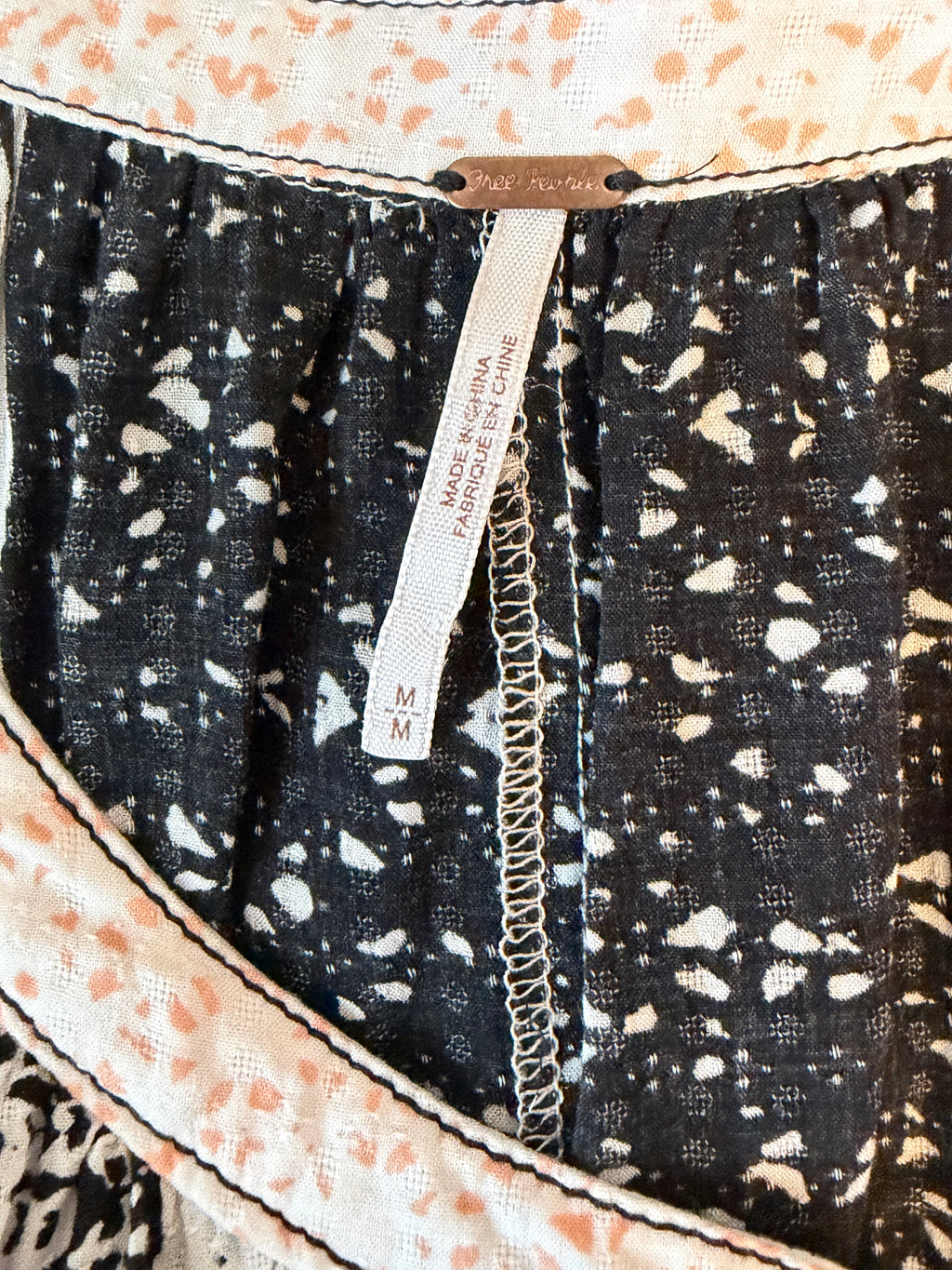 Close-up of a fabric with a black and white pattern and a visible brand label.