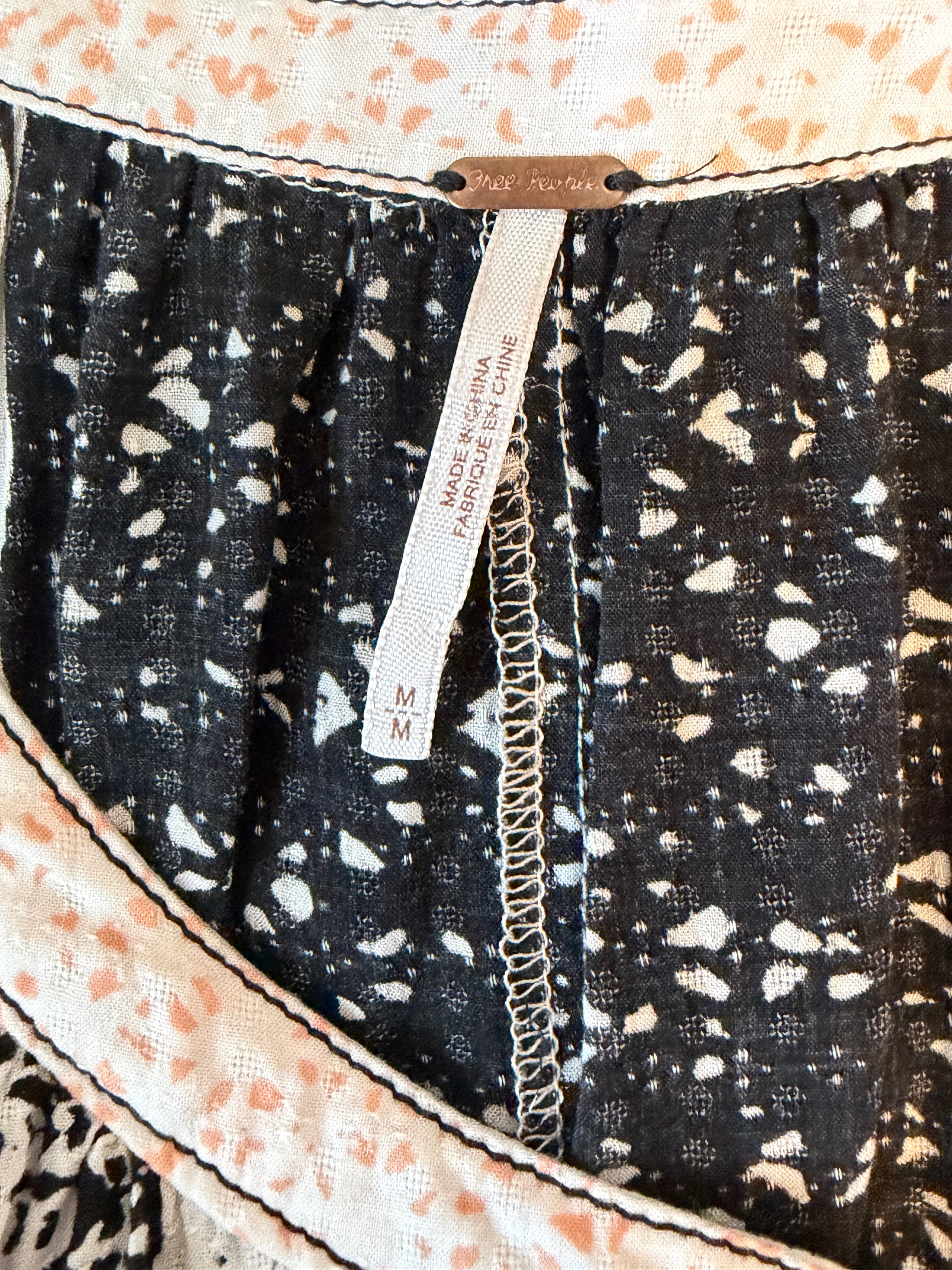 Close-up of a fabric with a black and white pattern and a visible brand label.