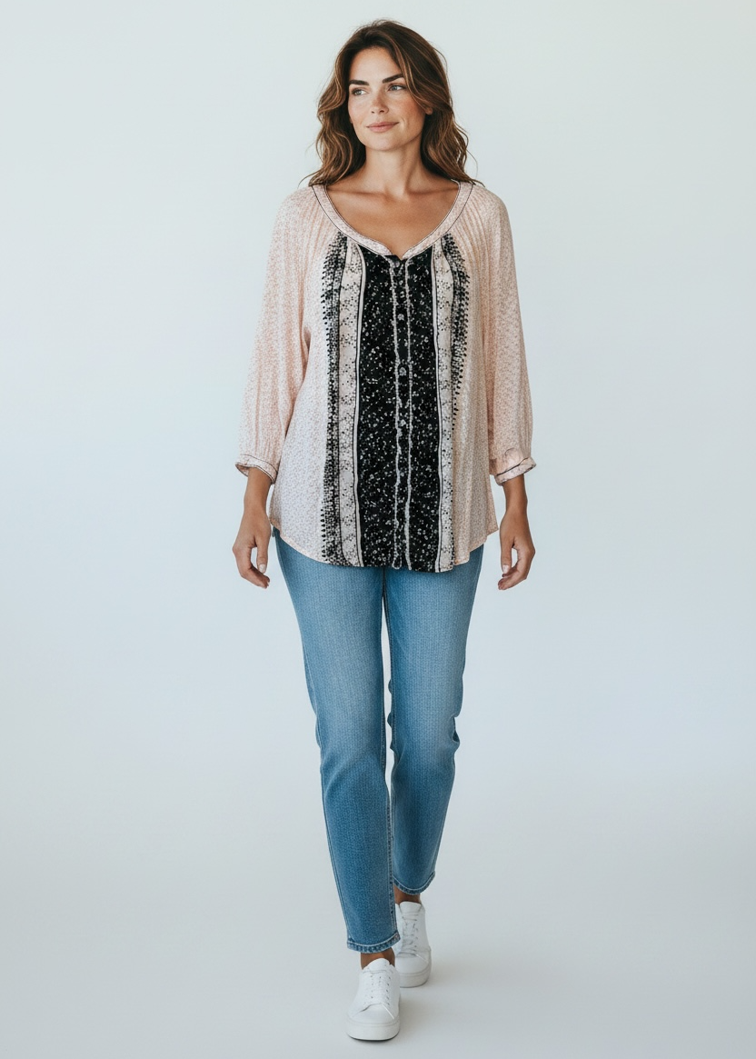 Woman wearing a light pink blouse with a black and white patterned top, blue jeans, and white sneakers on a white background.