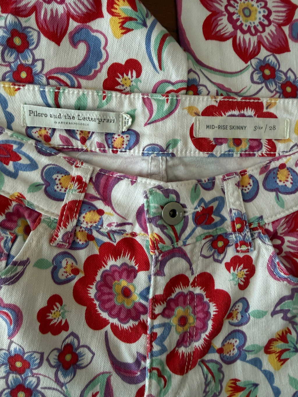 Colorful floral-patterned fabric with a brand label.
