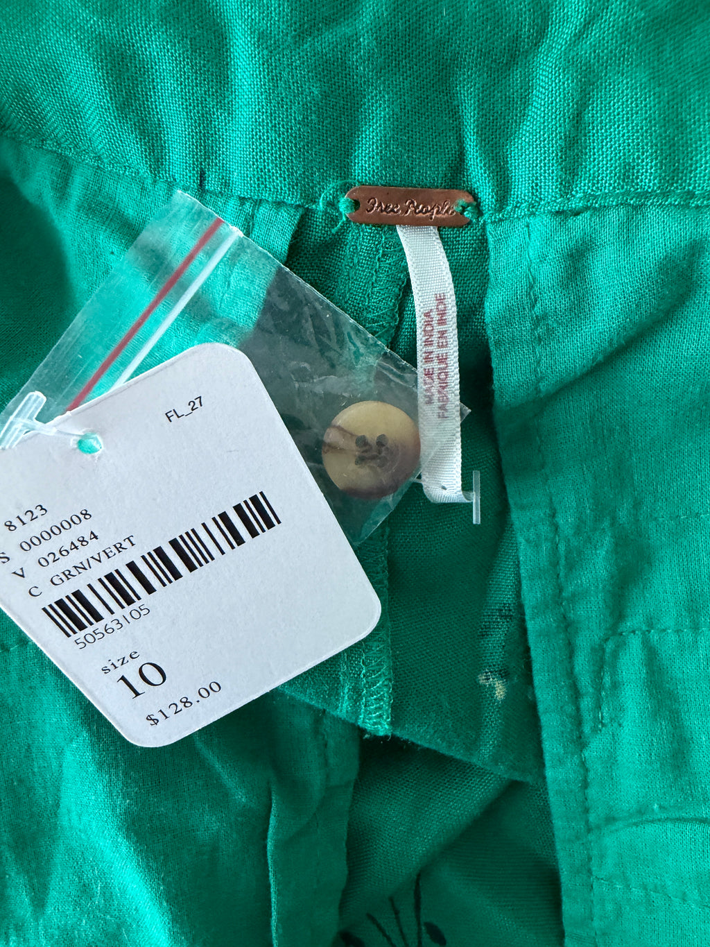 Green shirt with a tag displaying size 10 and price $128.00.