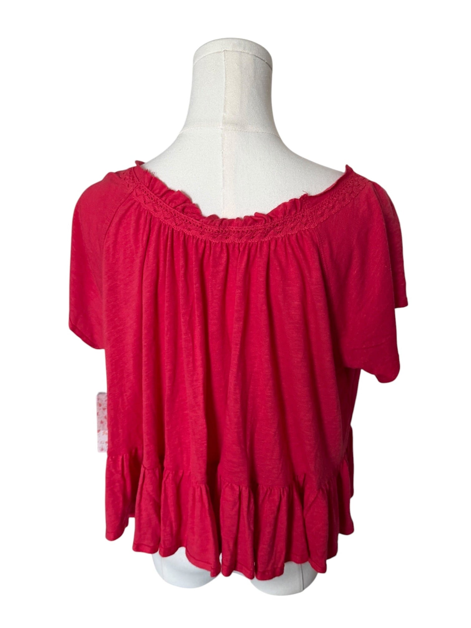 Red blouse on a mannequin against a white background