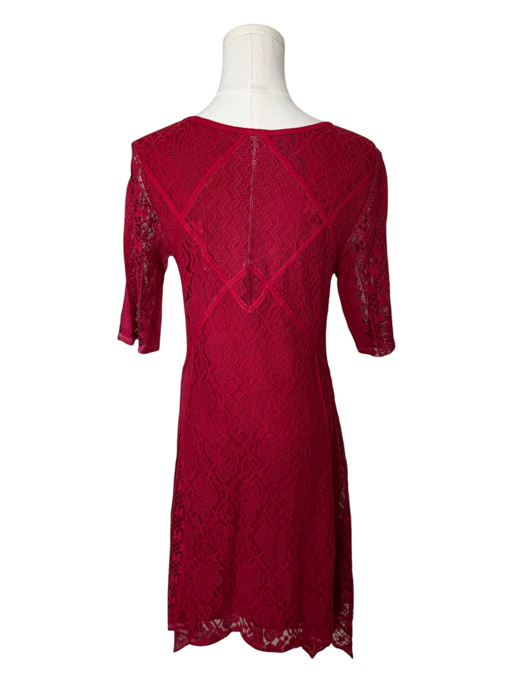 Red lace dress on a mannequin against a white background