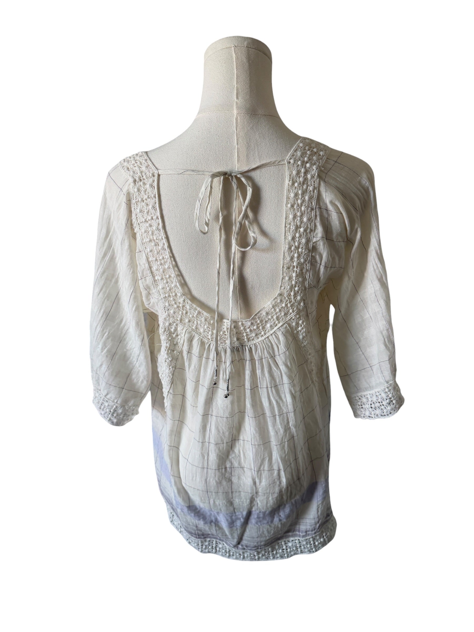 White lace top on a mannequin against a white background