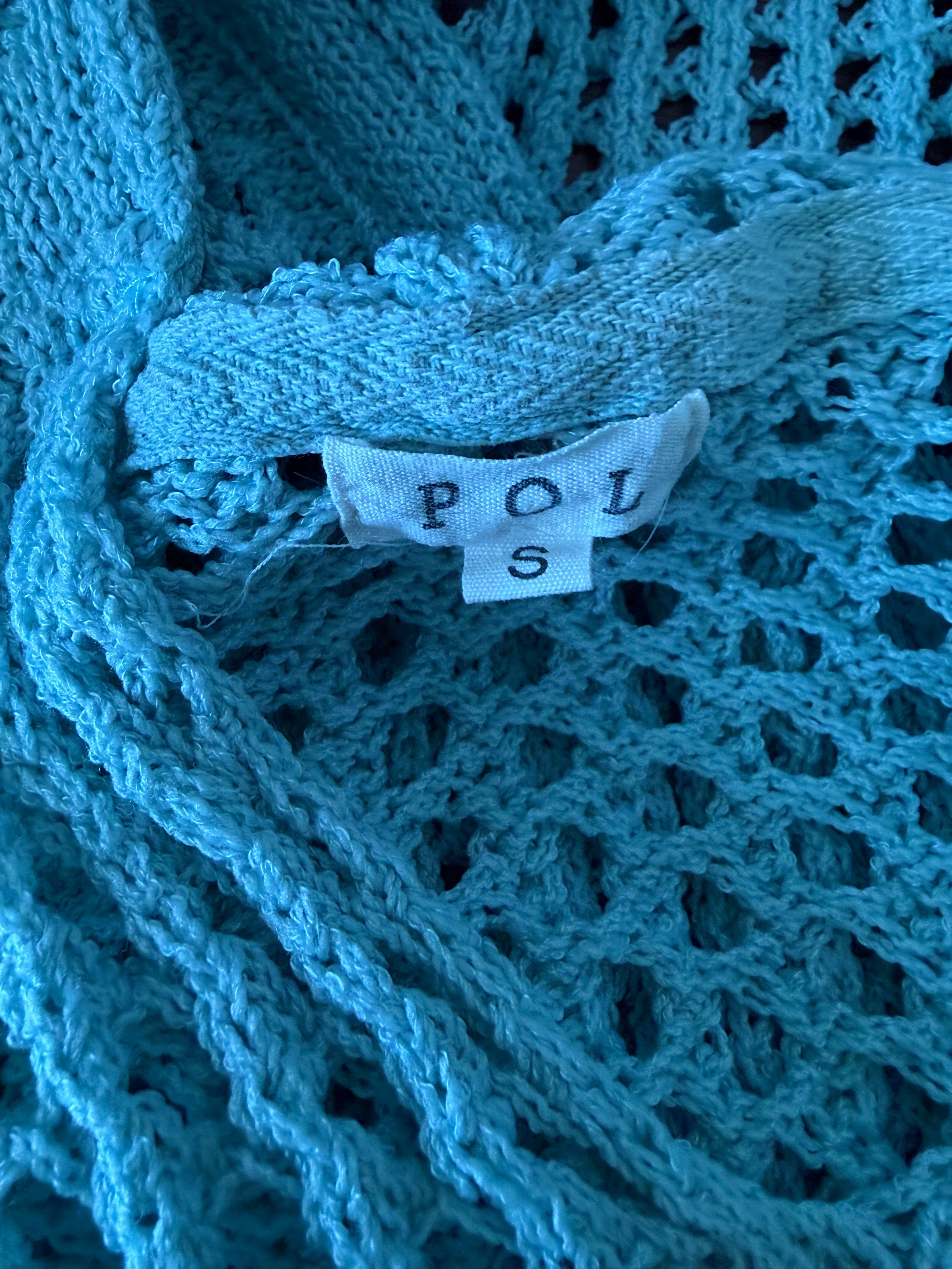 Close-up of a blue knitted fabric with a visible label.