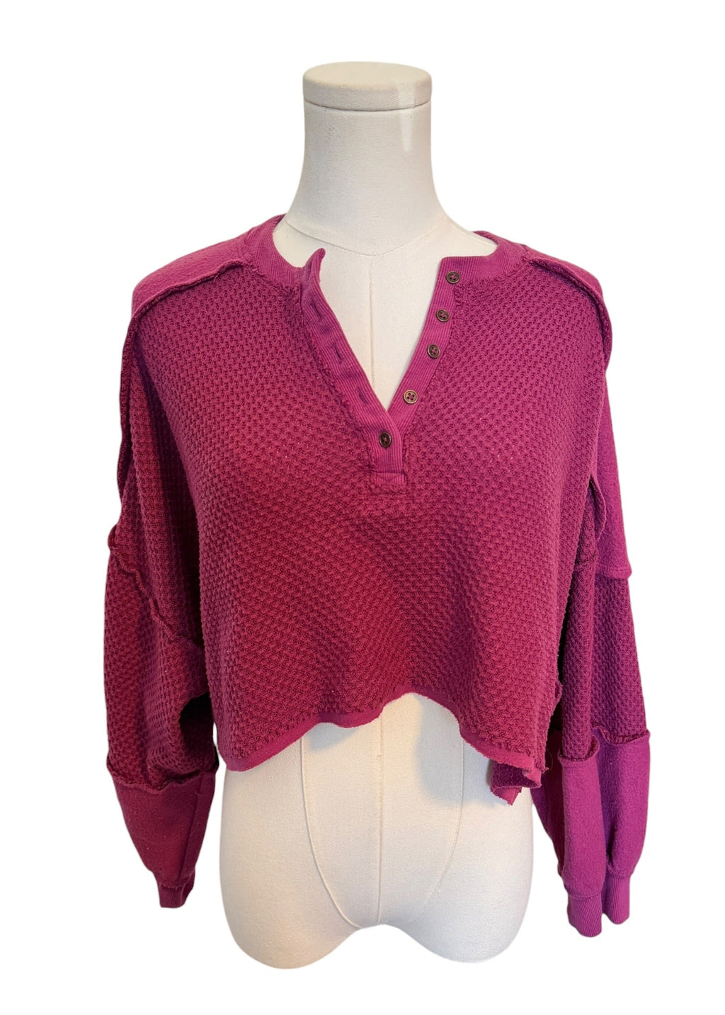 Pink textured blouse on a mannequin with a white background