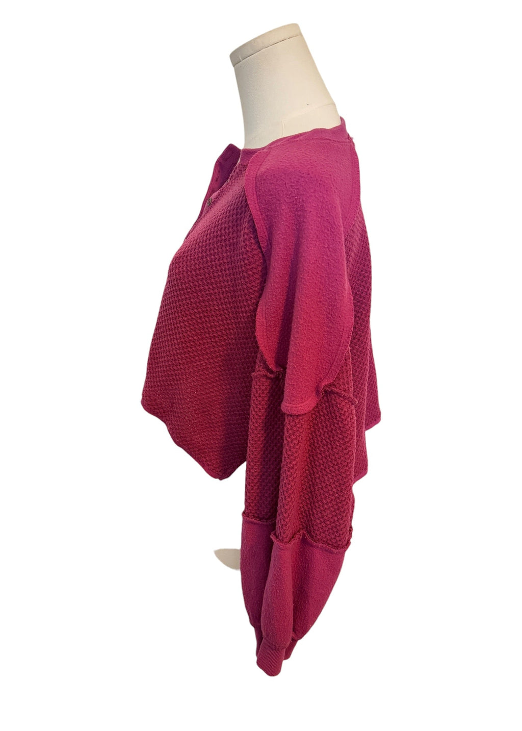 Red knitted sweater on a mannequin against a white background