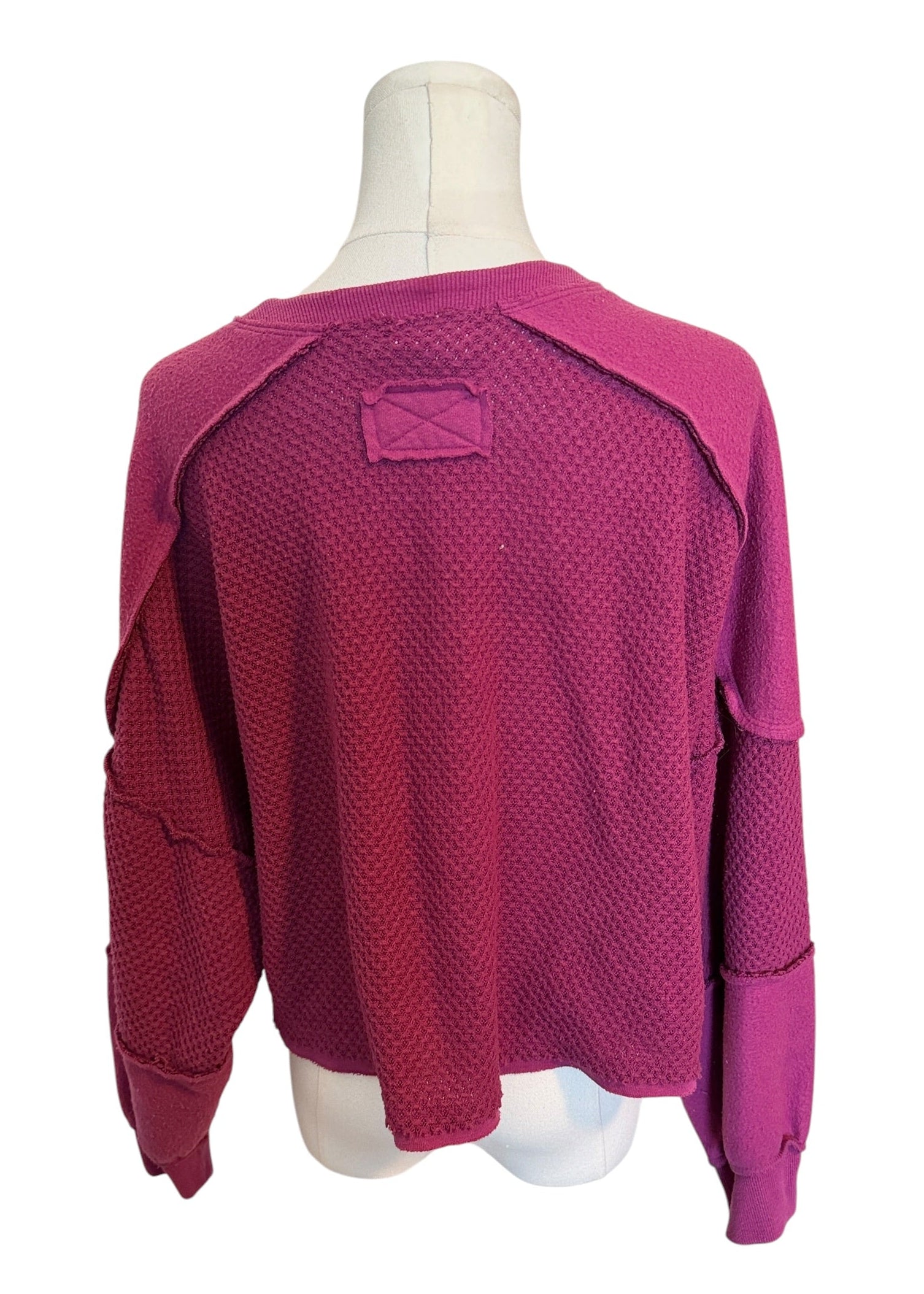 Pink textured sweater on a mannequin with a white background