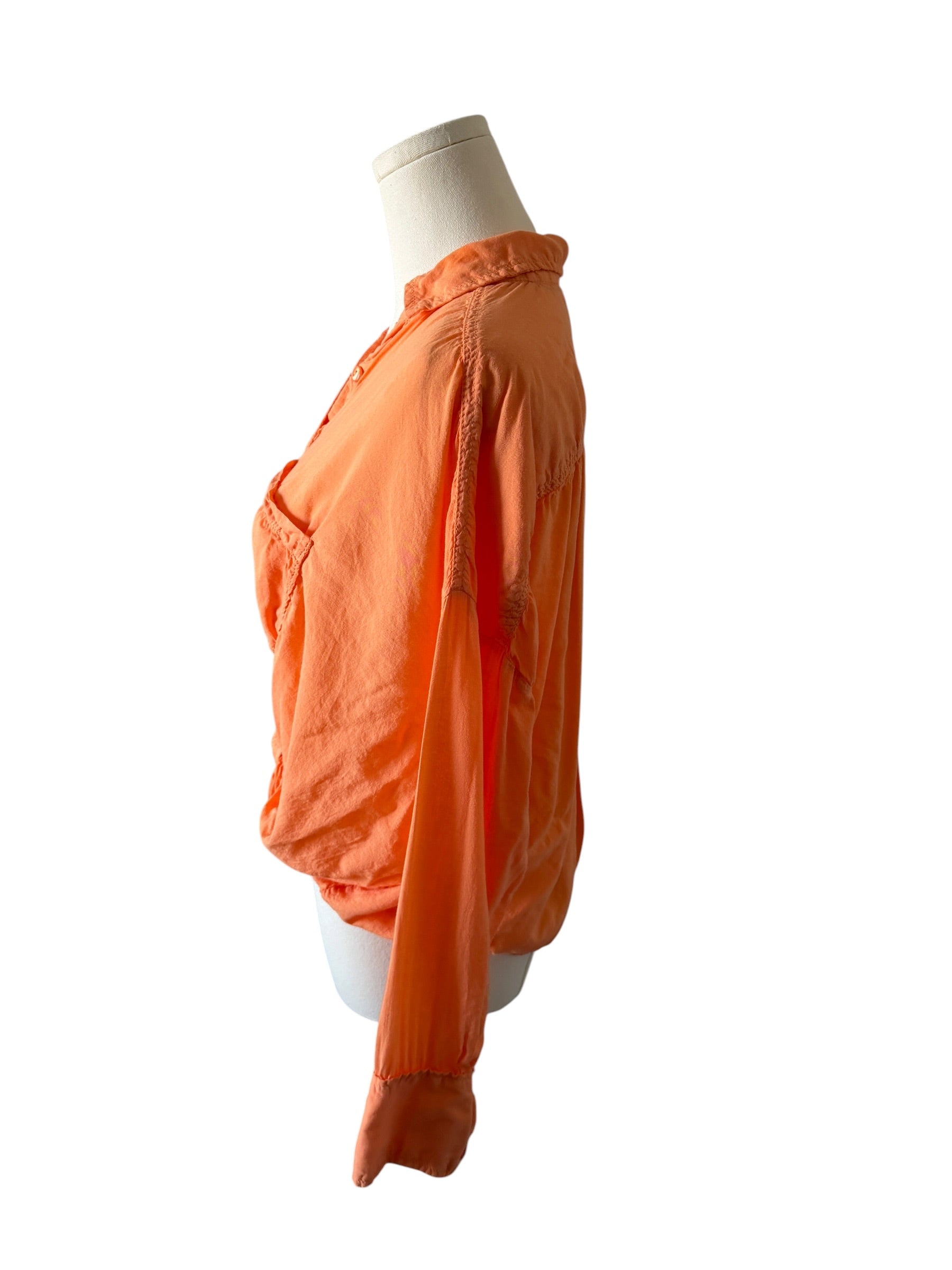 Orange shirt on a mannequin against a white background
