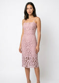 Woman wearing a pink lace dress against a white background