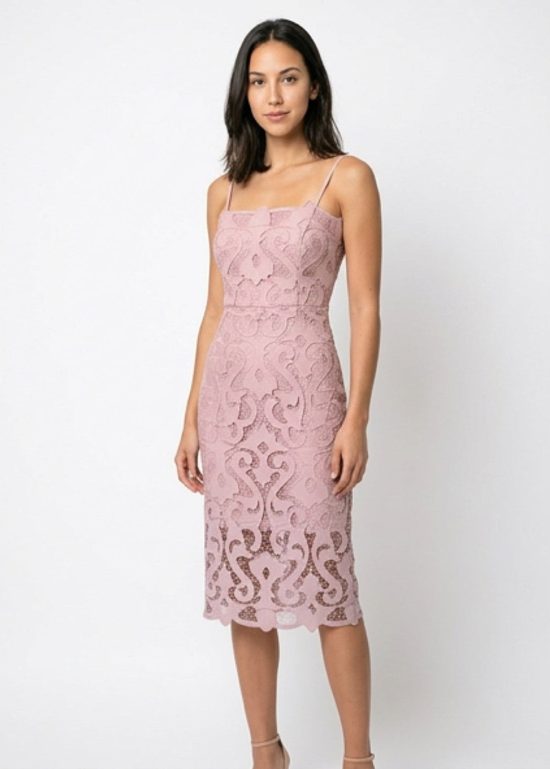 Woman wearing a pink lace dress against a white background