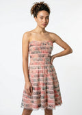 Woman wearing a strapless floral dress on a white background